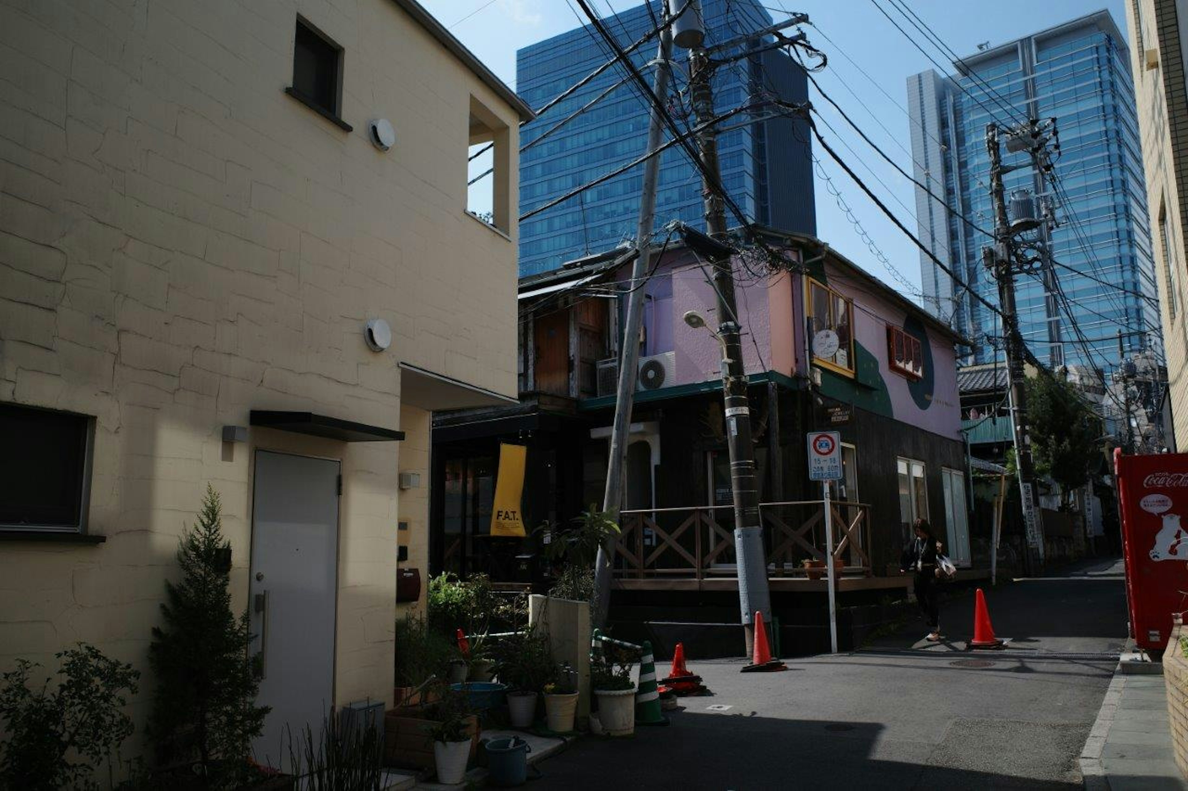 Bâtiment coloré dans une rue étroite avec des gratte-ciels contrastants