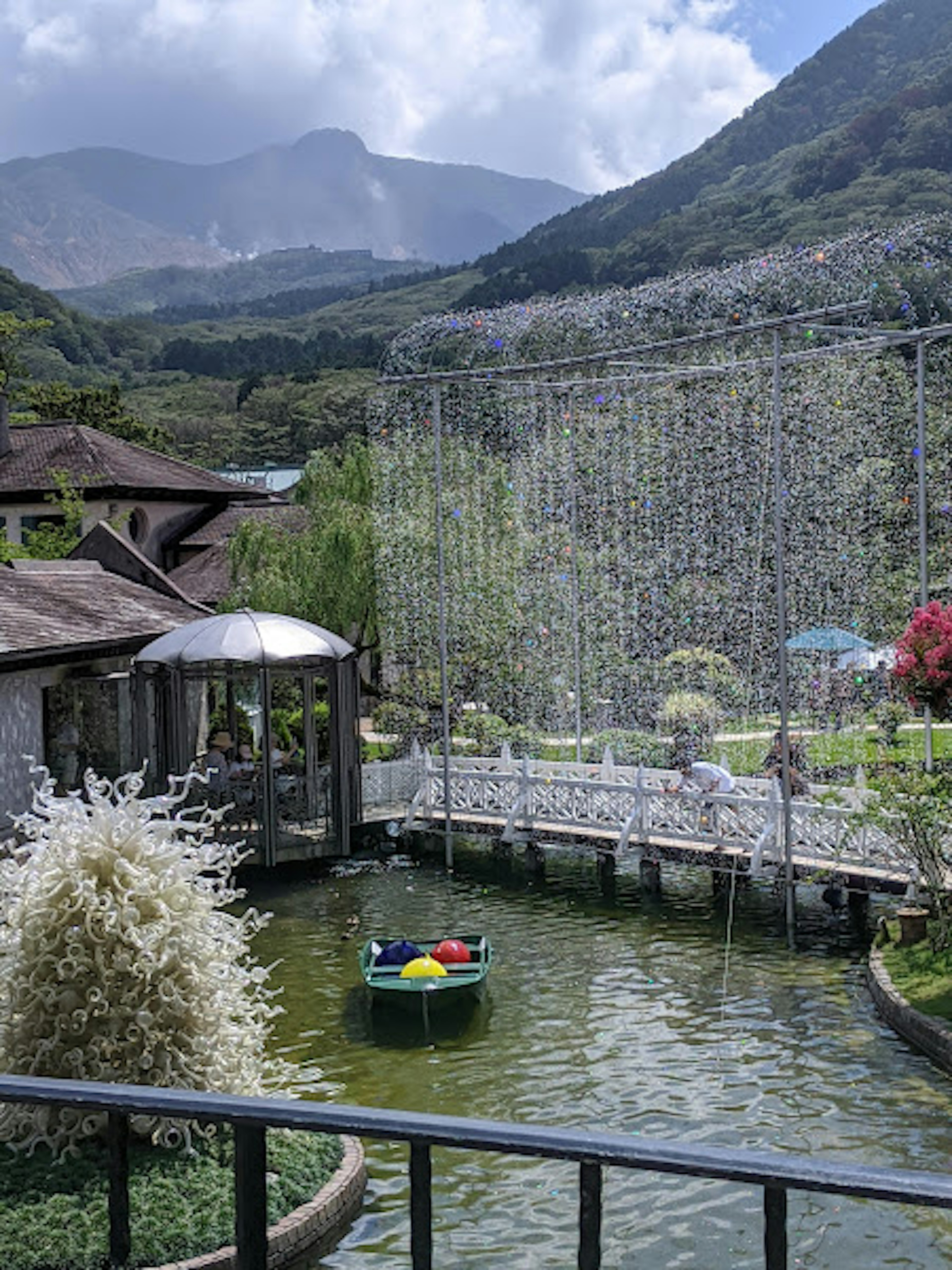 宁静的池塘景观，周围是山脉和一只小船