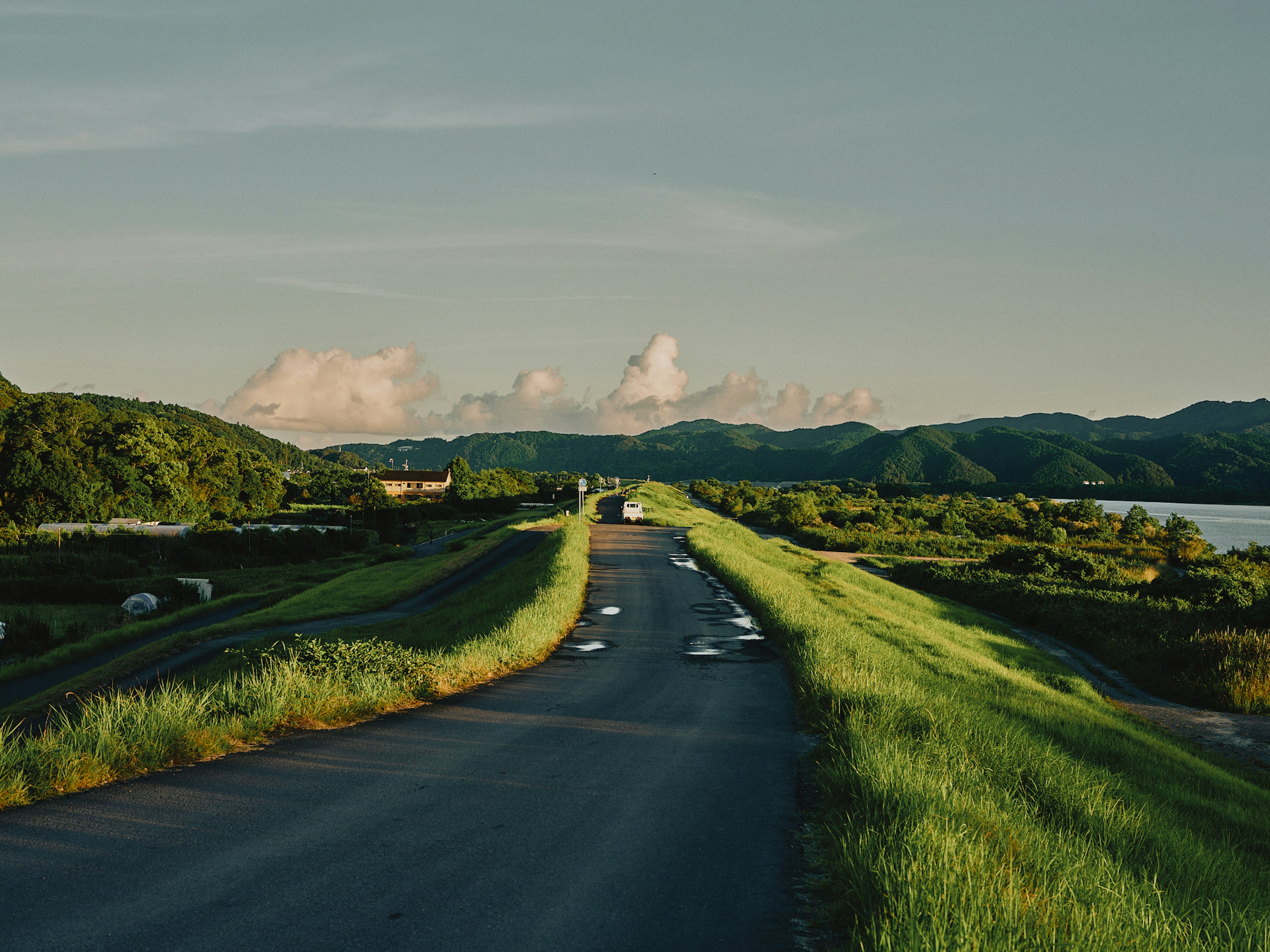 Strada circondata da erba verde e paesaggio fluviale