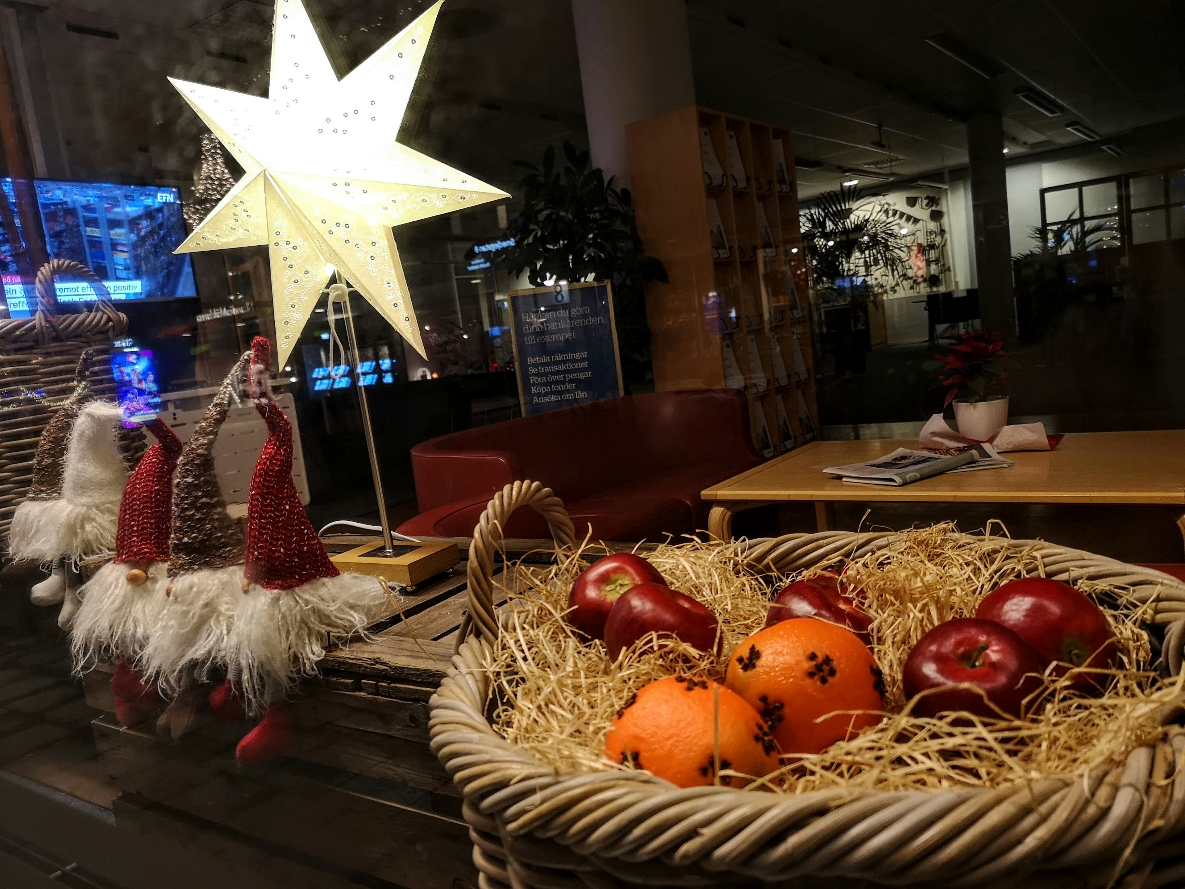 Ein gemütlicher Raum mit einer sternförmigen Lampe und einem Korb mit Äpfeln und Orangen