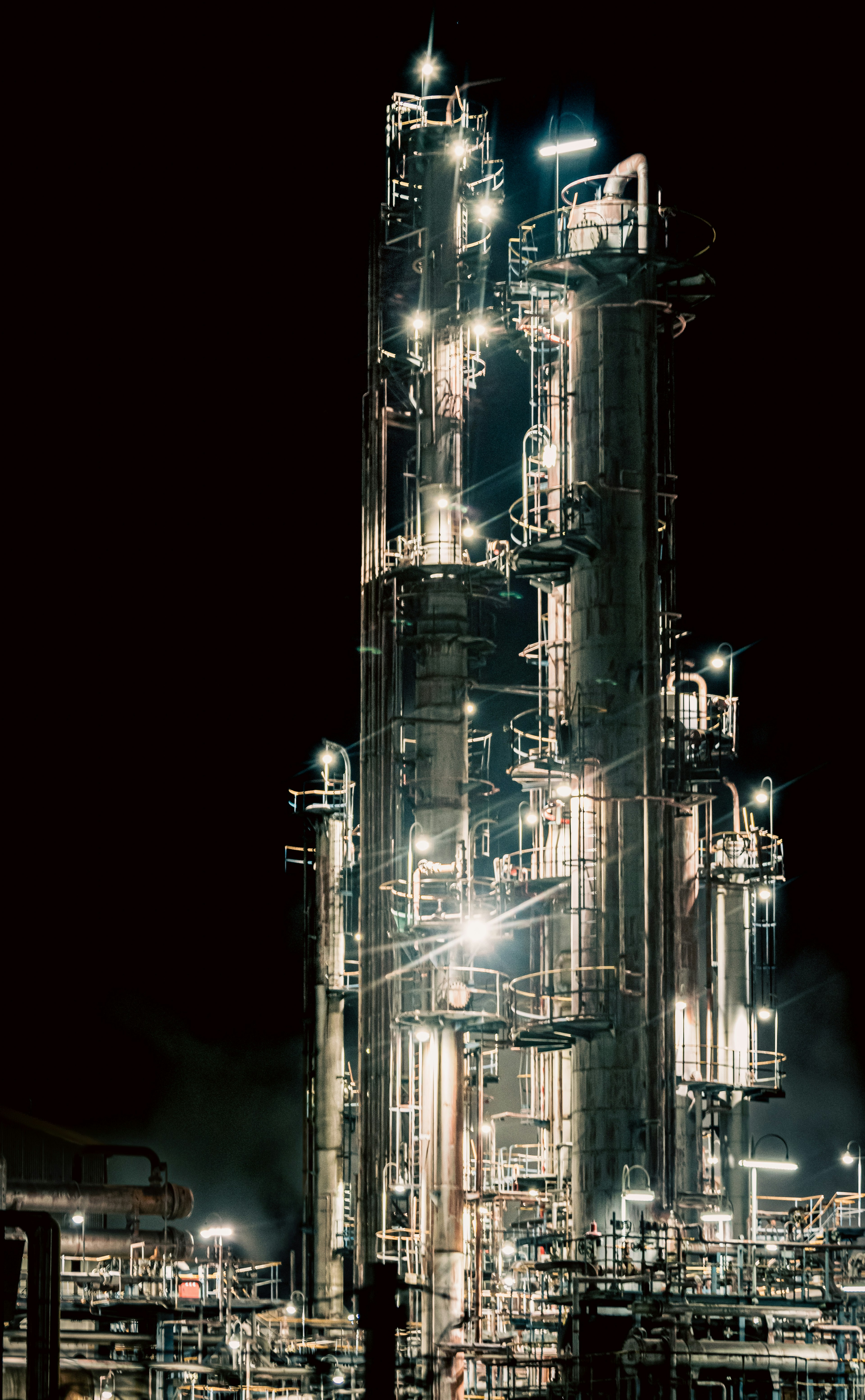 Illuminated industrial plant tower at night