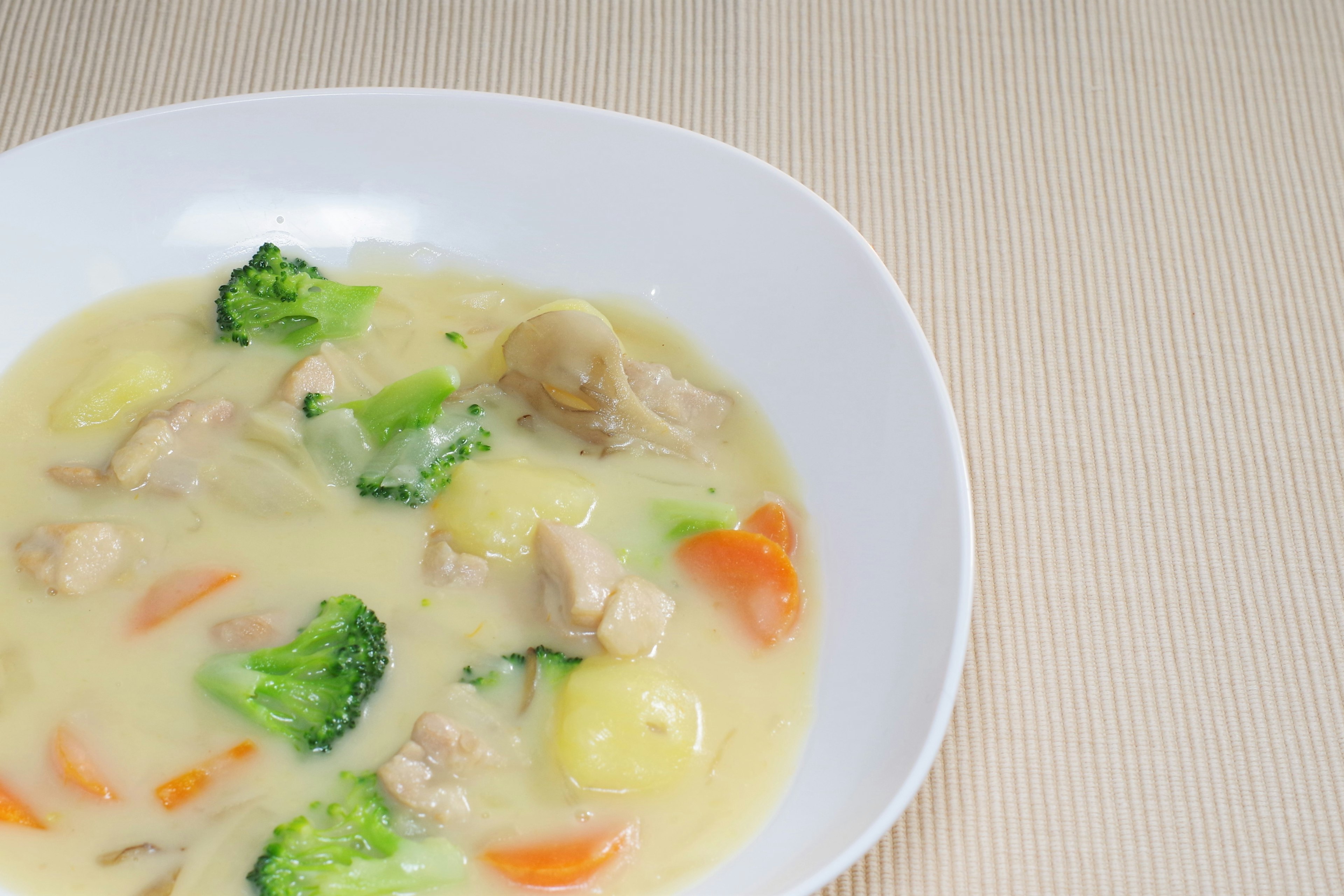 Creamy chicken and vegetable soup served in a white bowl