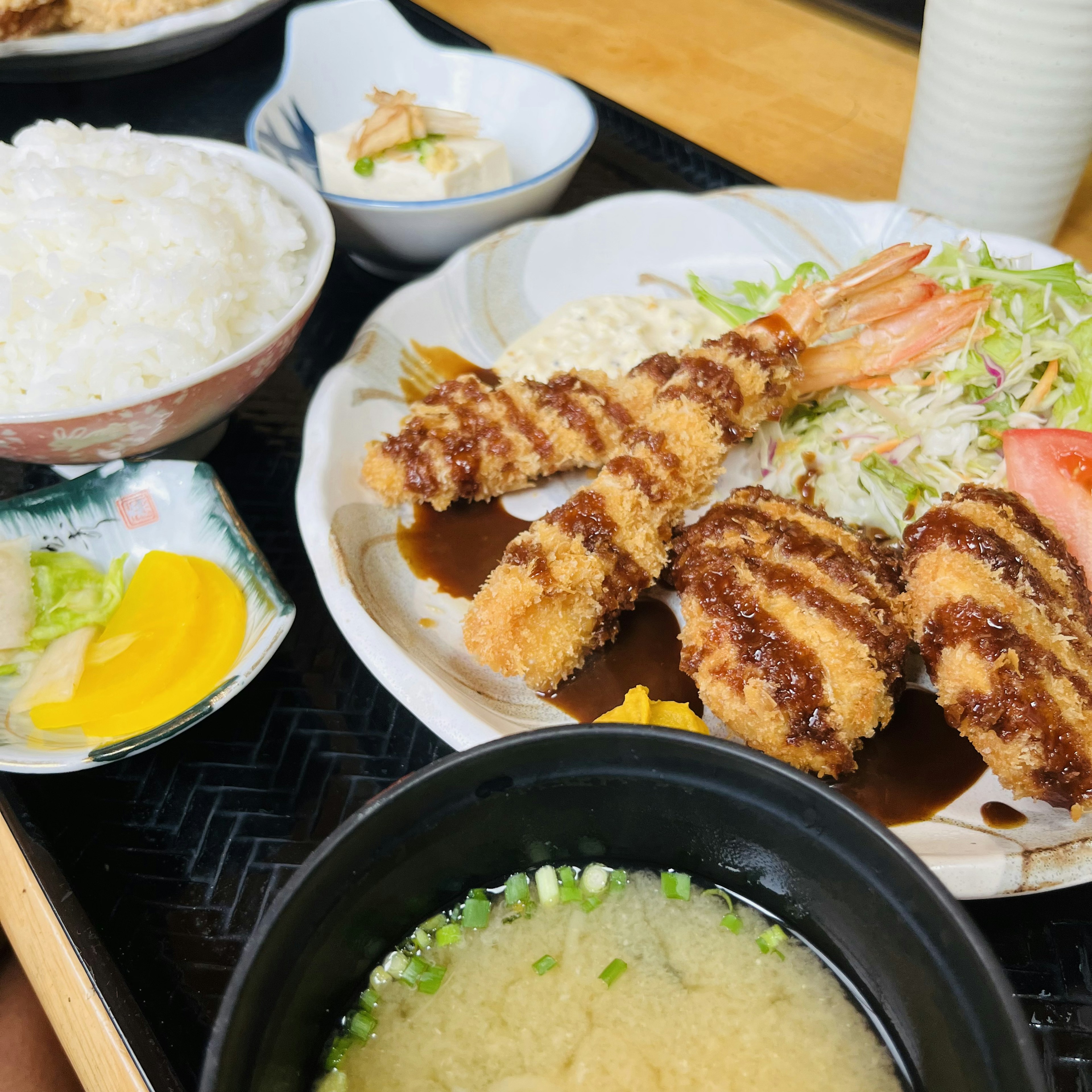 Leckere japanische Mahlzeit mit gebratenem Hühnchen und Garnelen-Tempura serviert mit Salat und Reis Misosuppe