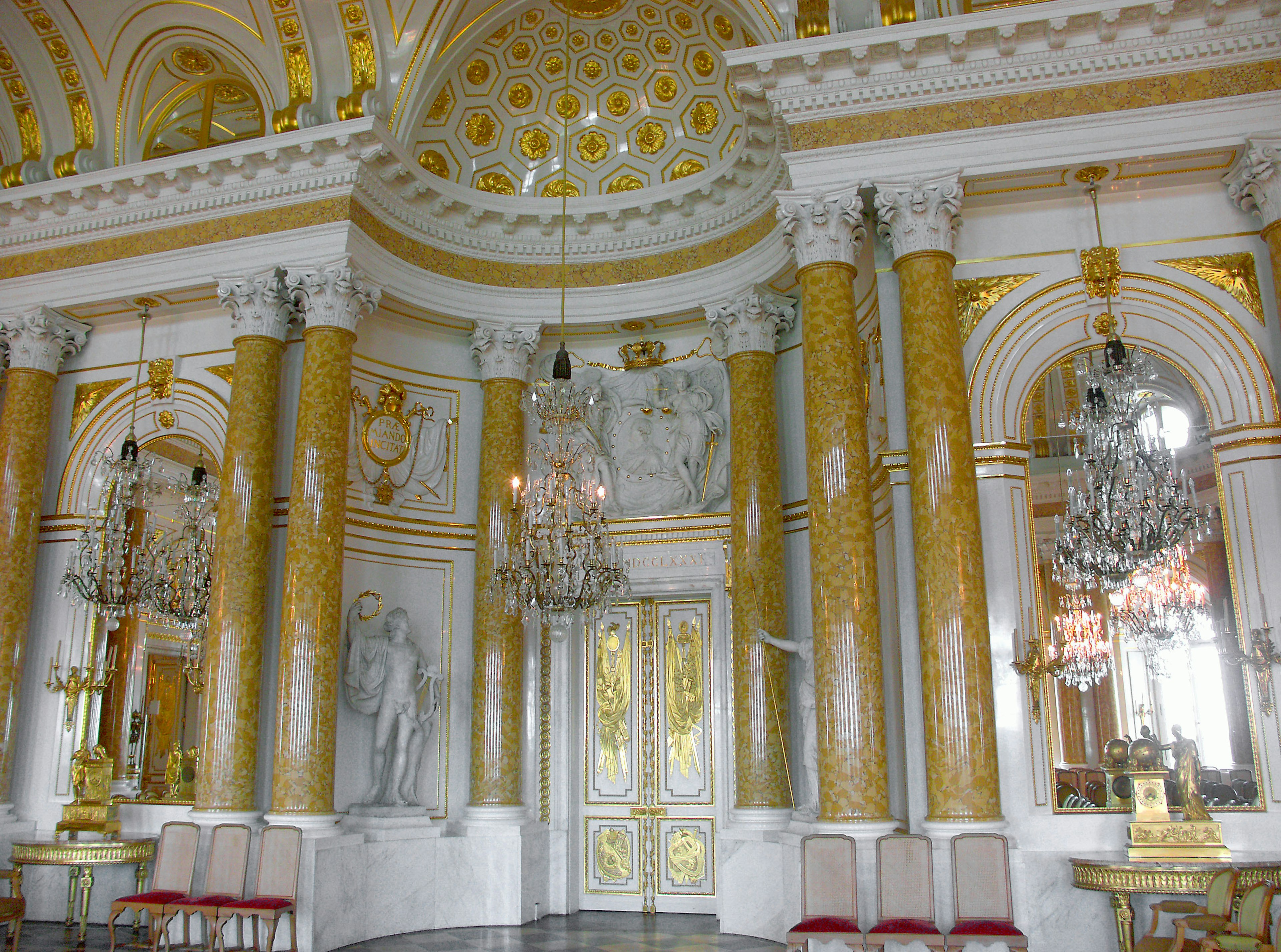 Luxurious room interior featuring golden columns and chandeliers