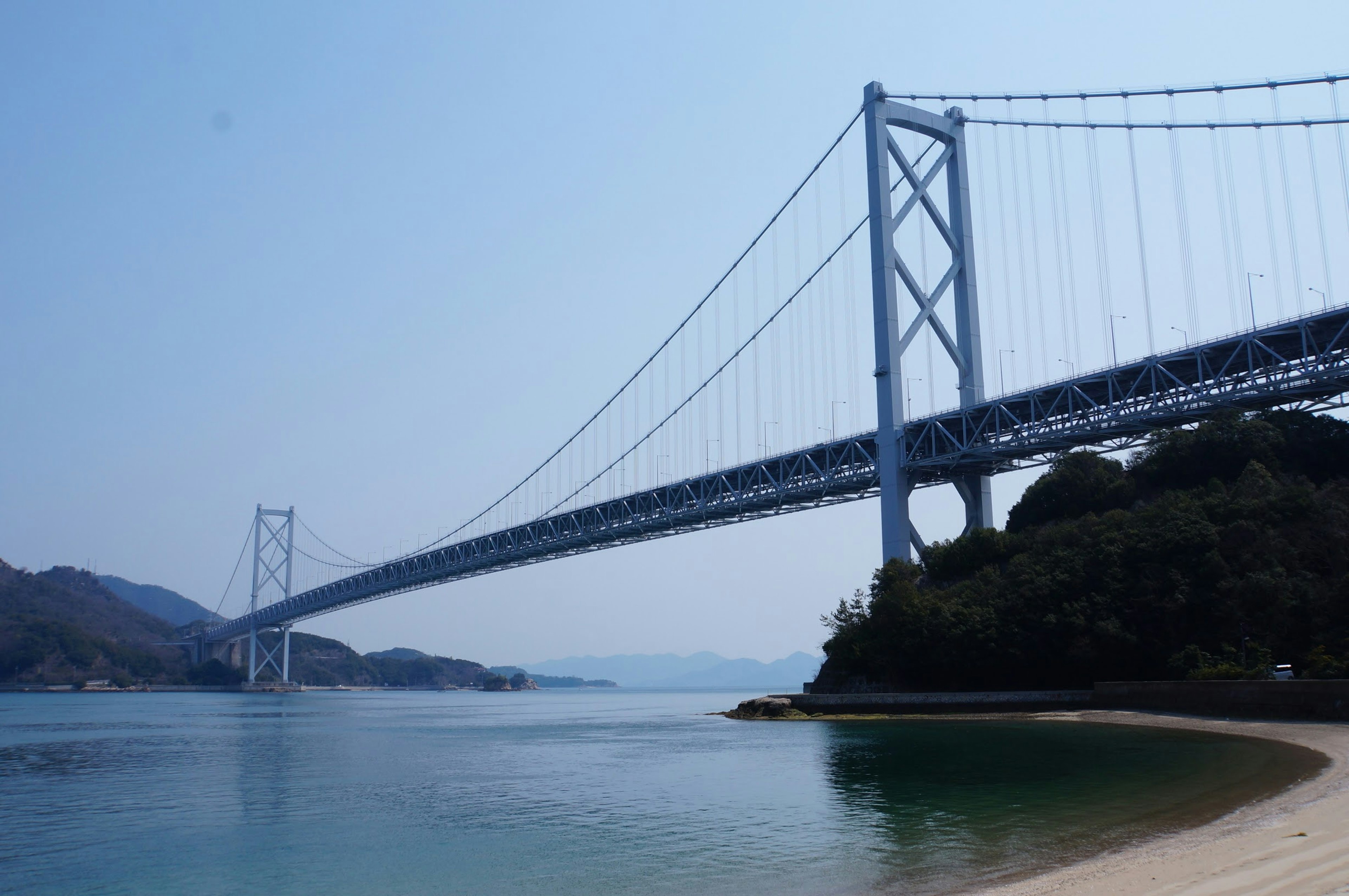 Scenic view of a white bridge spanning over calm waters