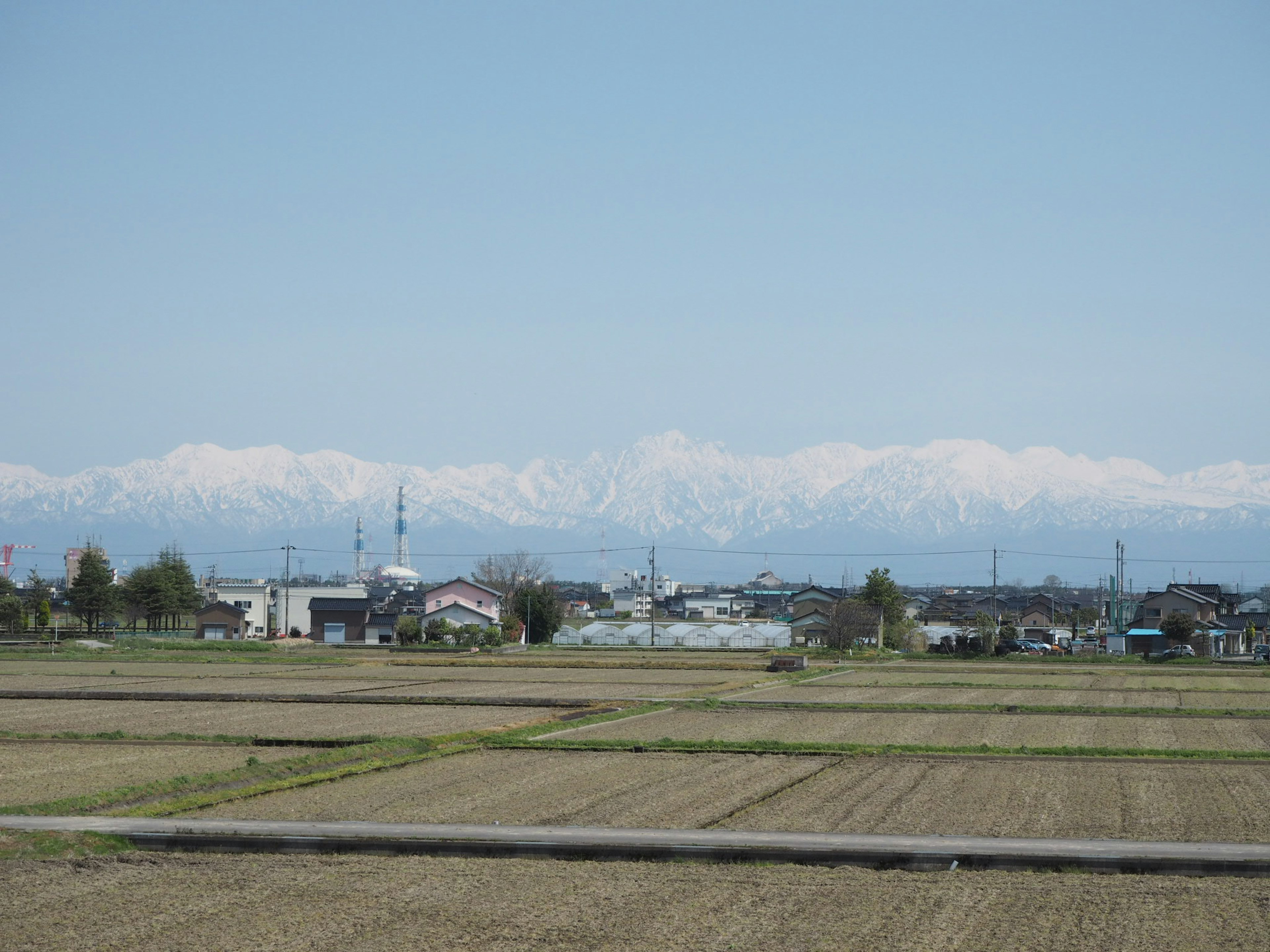 Montagne innevate e paesaggio rurale esteso