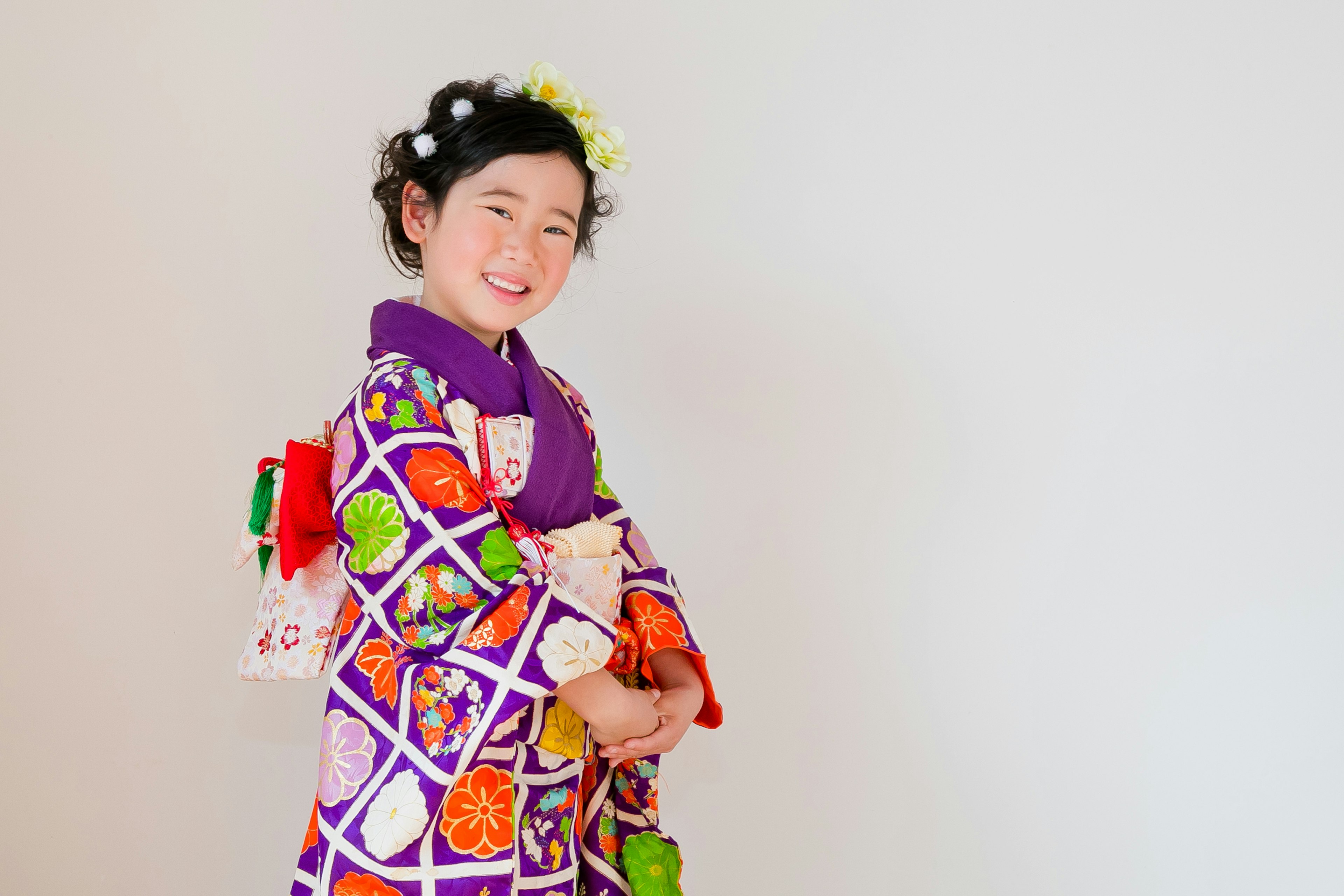 A girl smiling in a colorful purple kimono with floral patterns