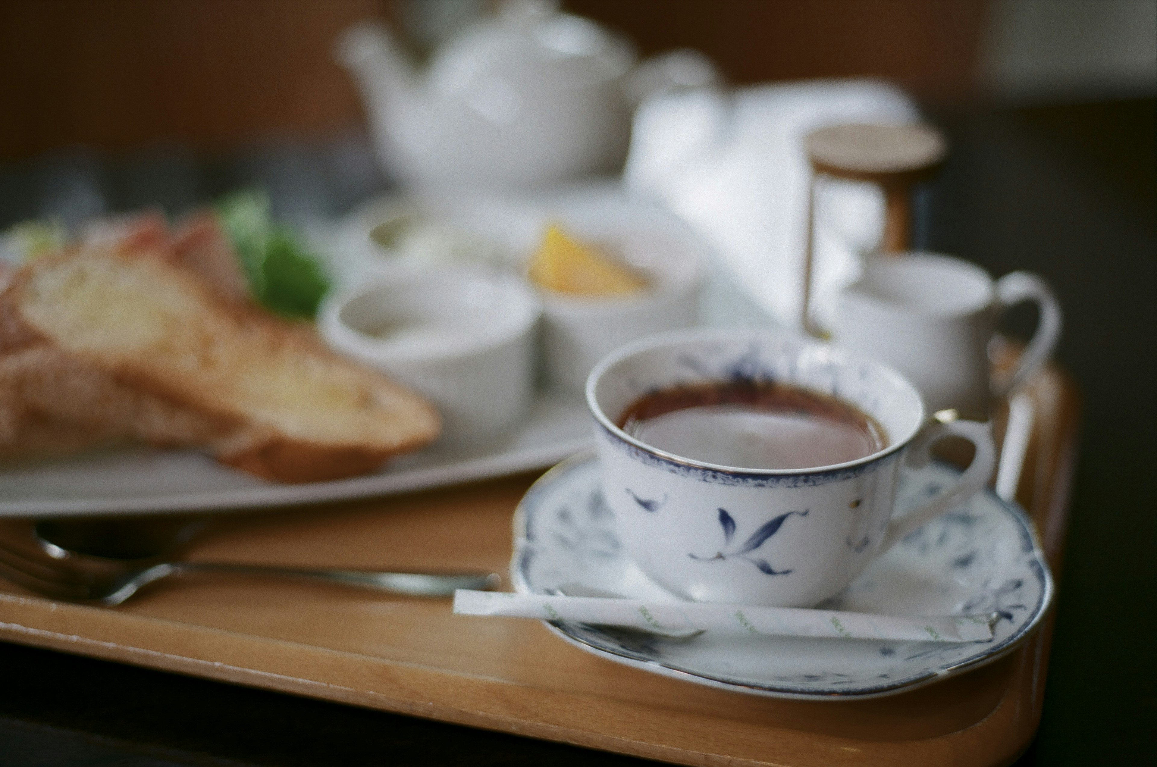 Cangkir kopi yang indah dengan nampan sarapan yang termasuk roti panggang dan bumbu