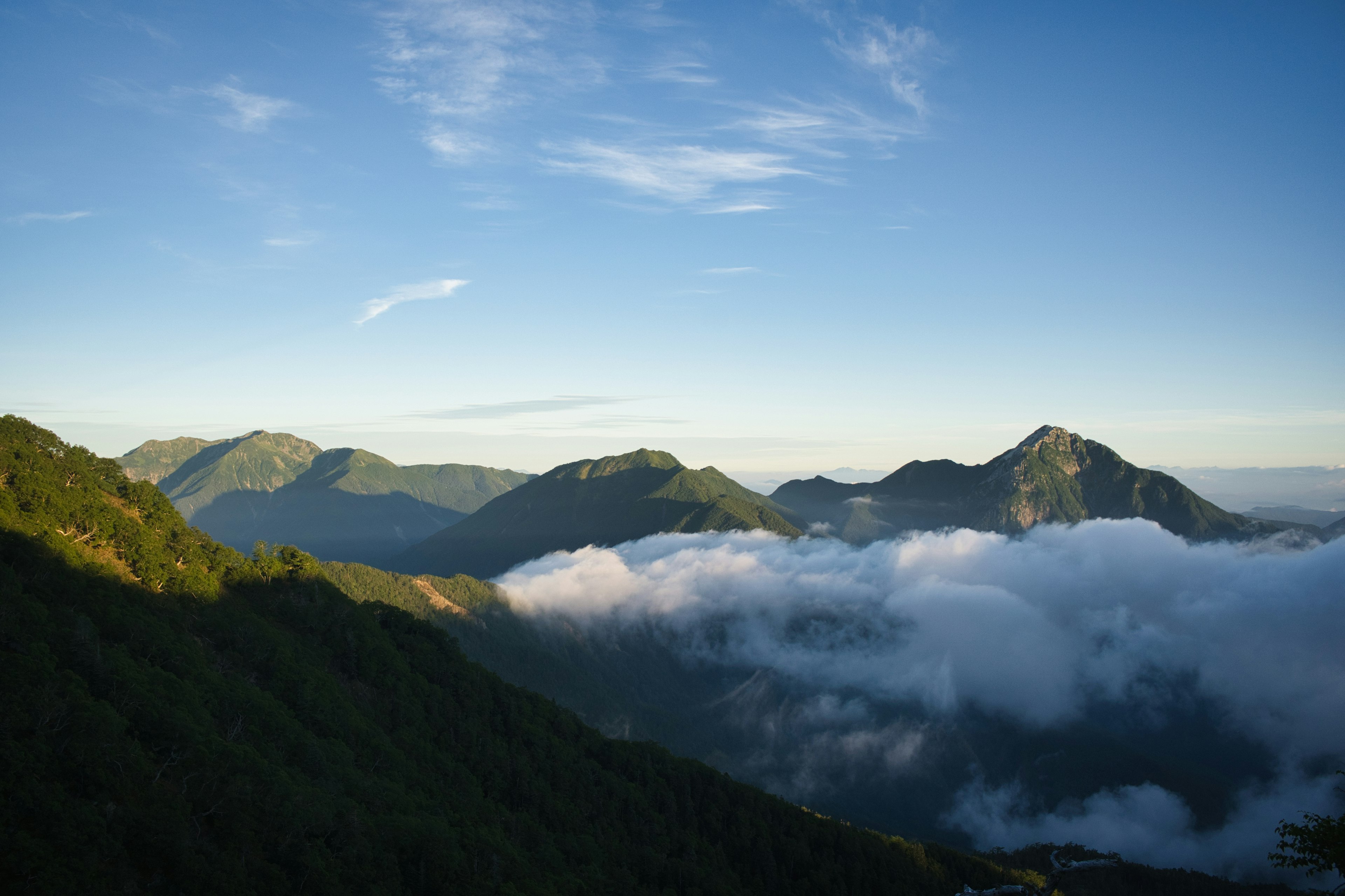 Panoramablick auf Berge und Wolken unter einem klaren blauen Himmel