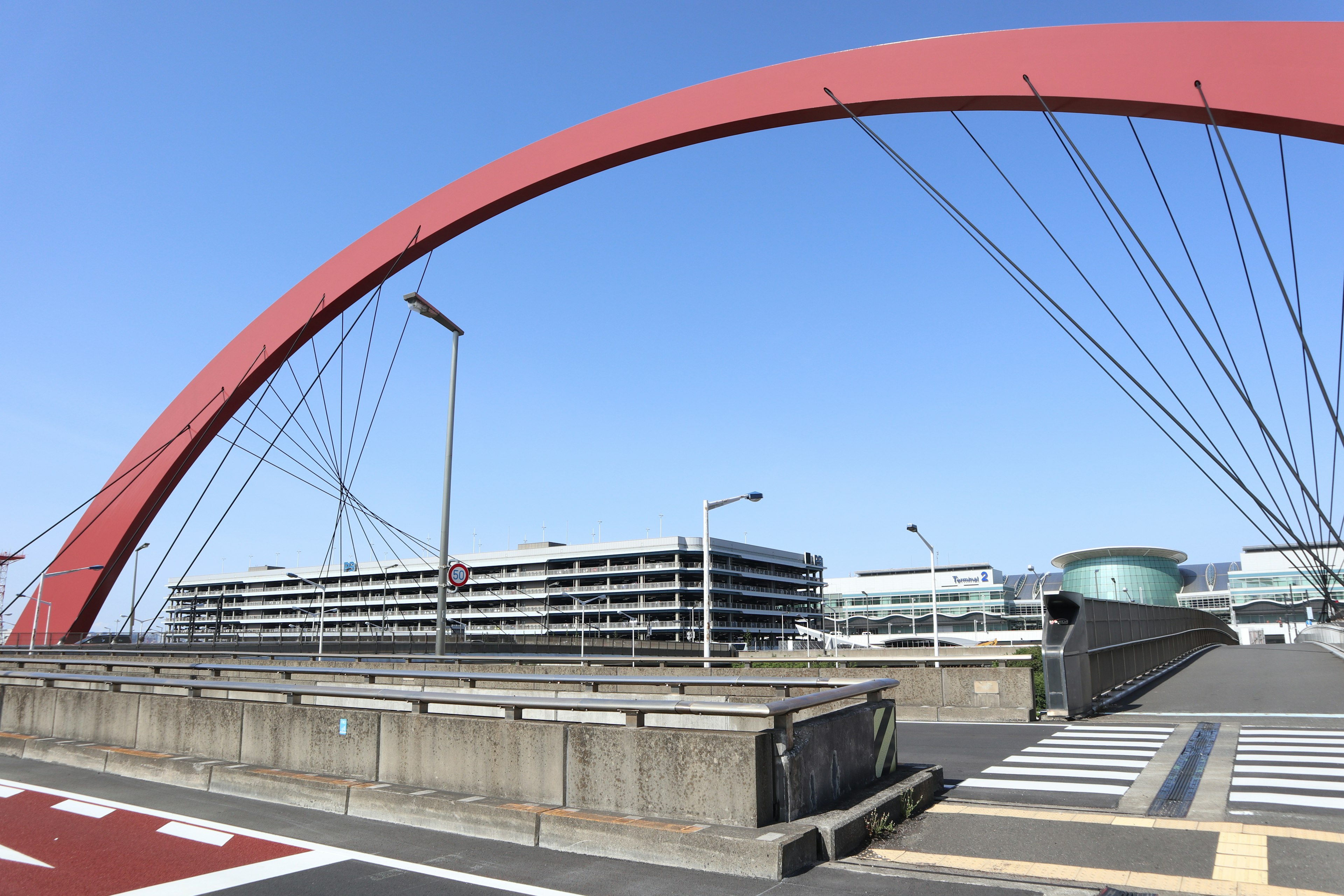 Red arch bridge with modern buildings in the background