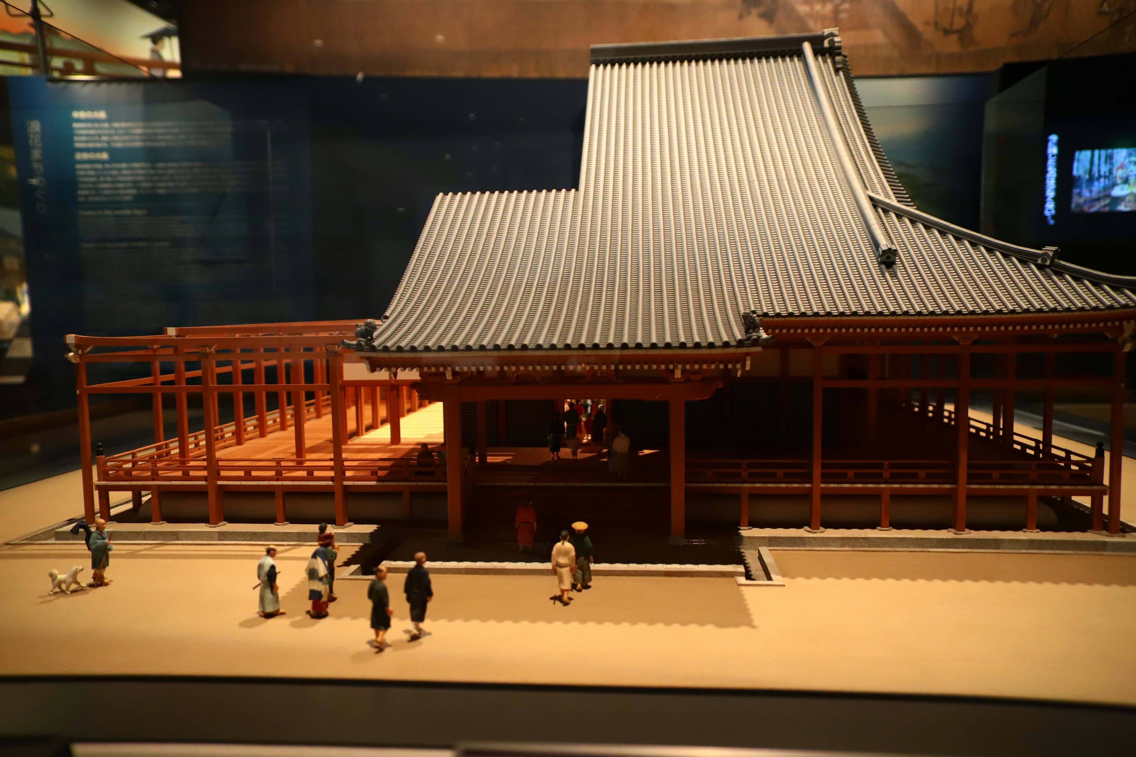 Traditional Japanese architectural model with figures on display