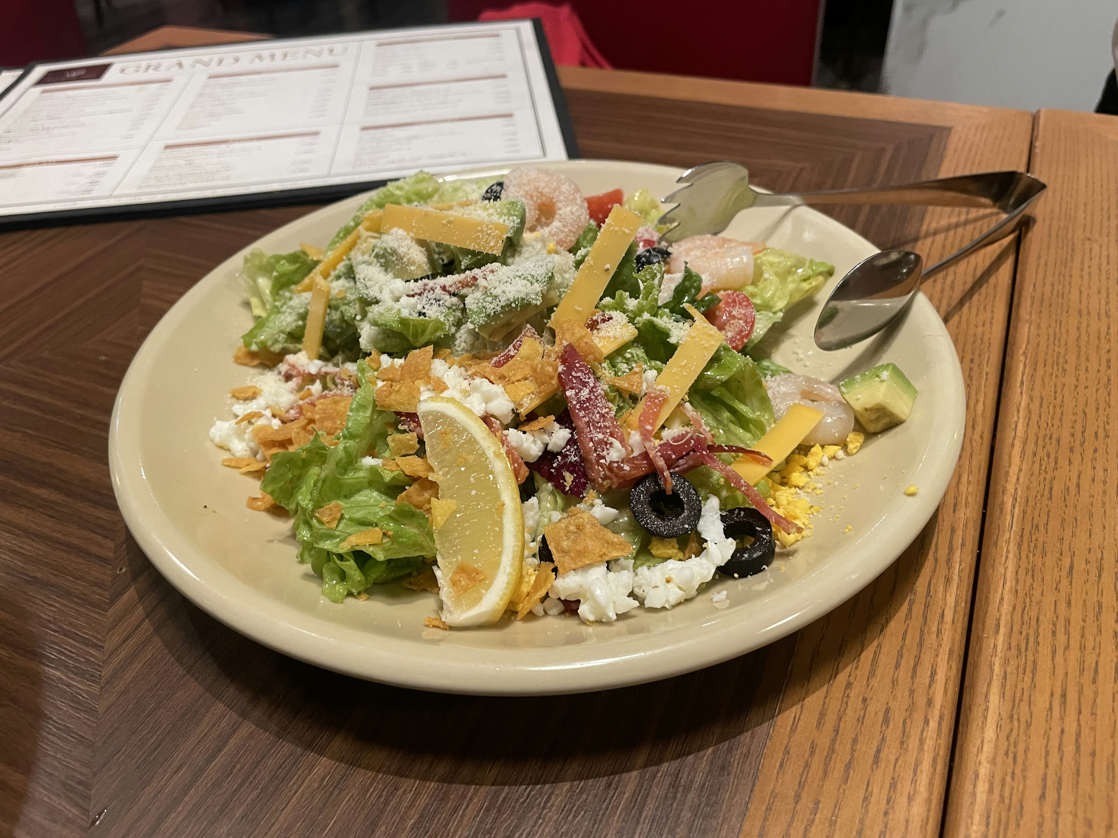 Un plato de ensalada fresca con lechuga, tomates, queso y aceitunas