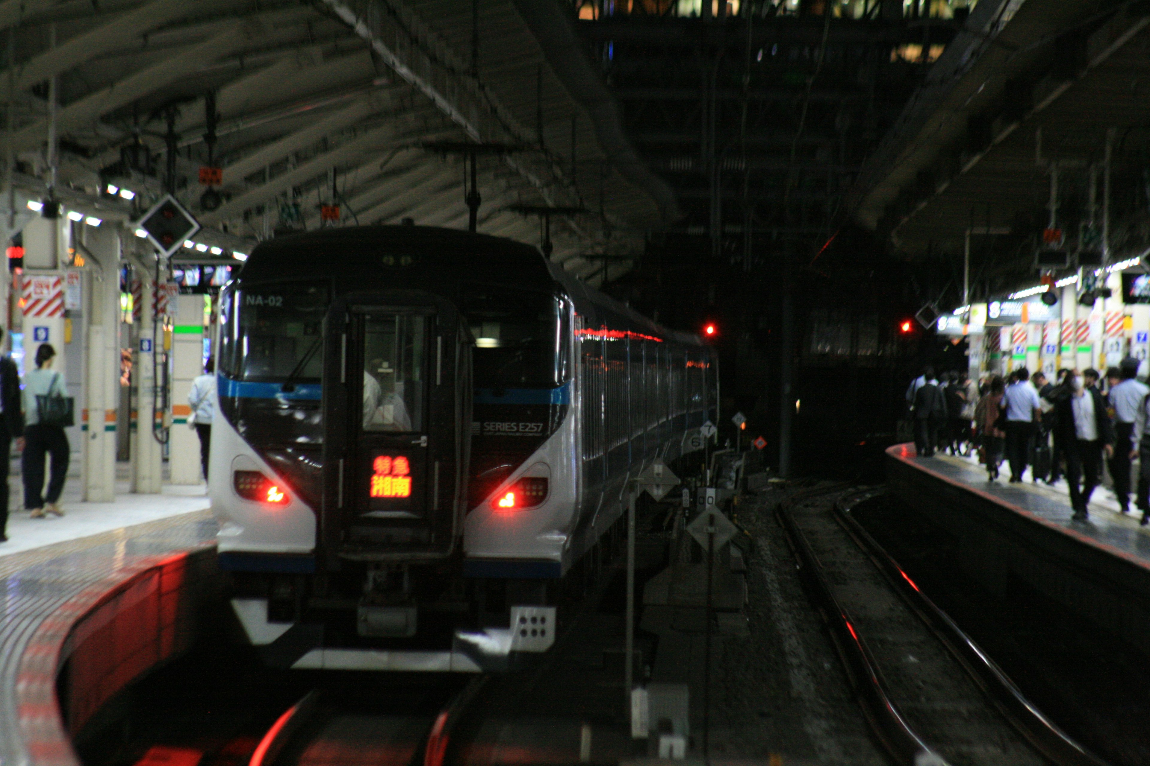 Train arrêté à une station pendant la nuit avec des plateformes lumineuses