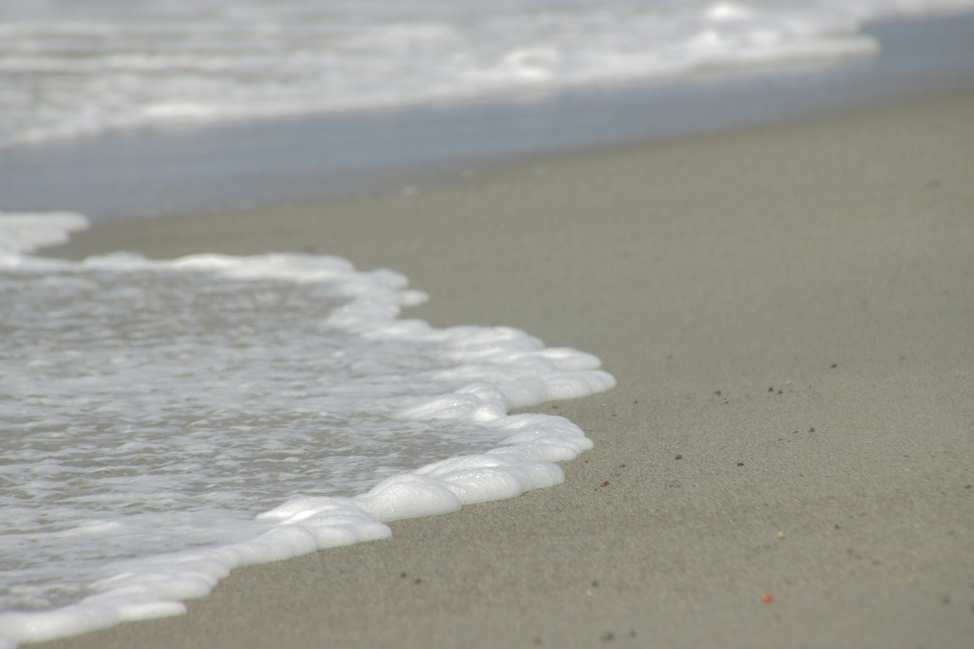 Onde che si infrangono su una spiaggia sabbiosa