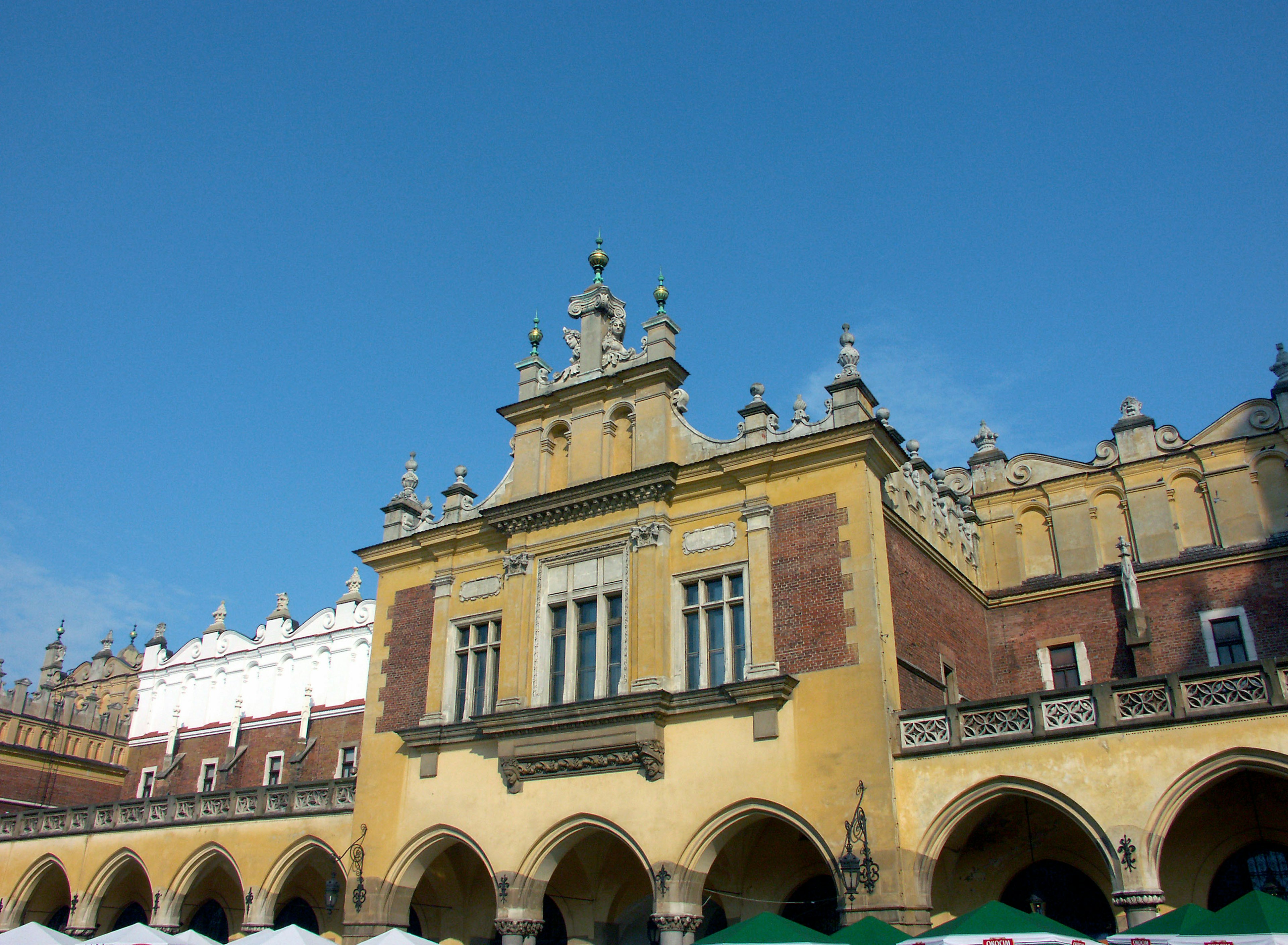 Außenansicht eines historischen Gebäudes auf dem Marktplatz von Krakau mit blauem Himmel im Hintergrund