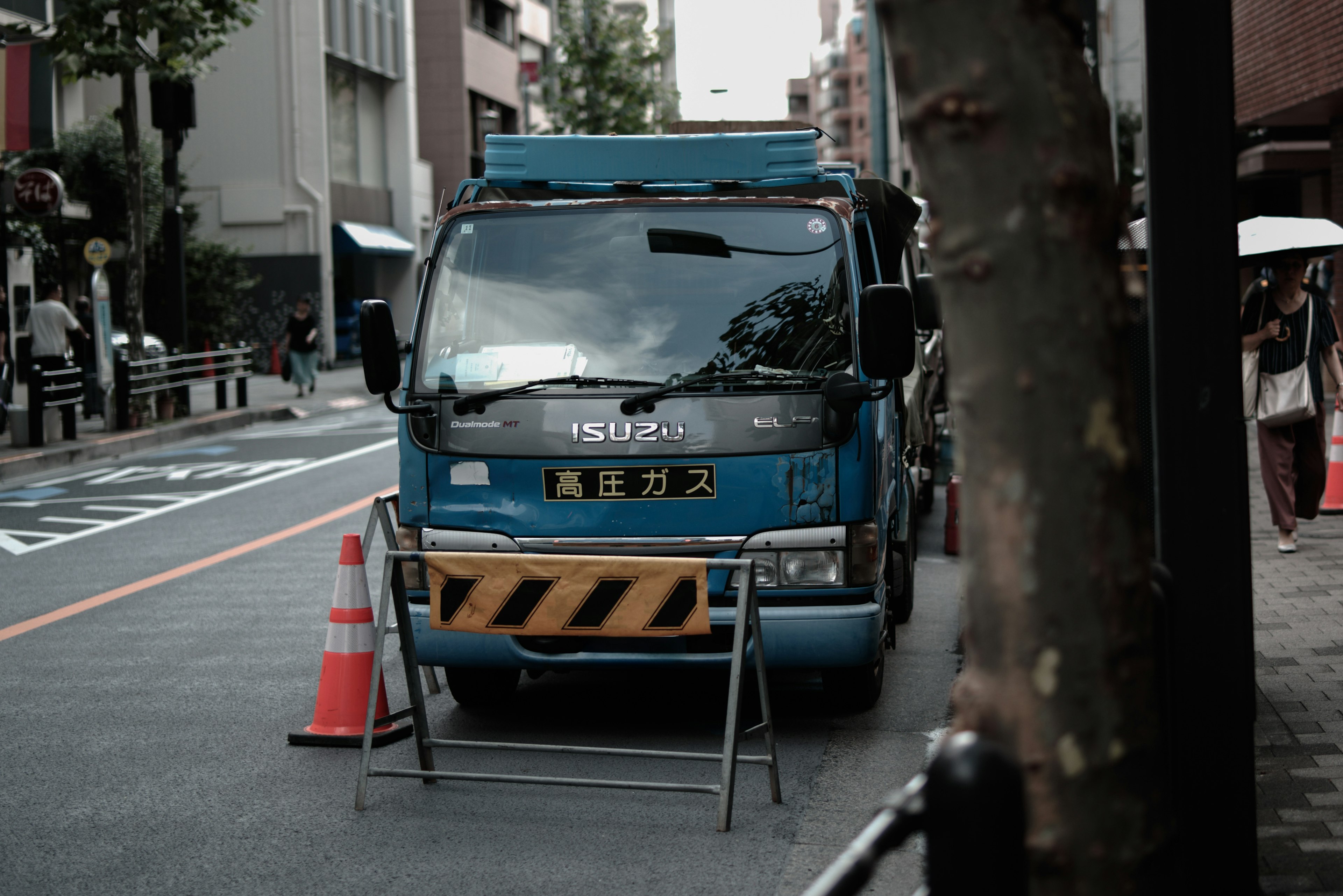 蓝色卡车停在街上，附近有交通锥和路障