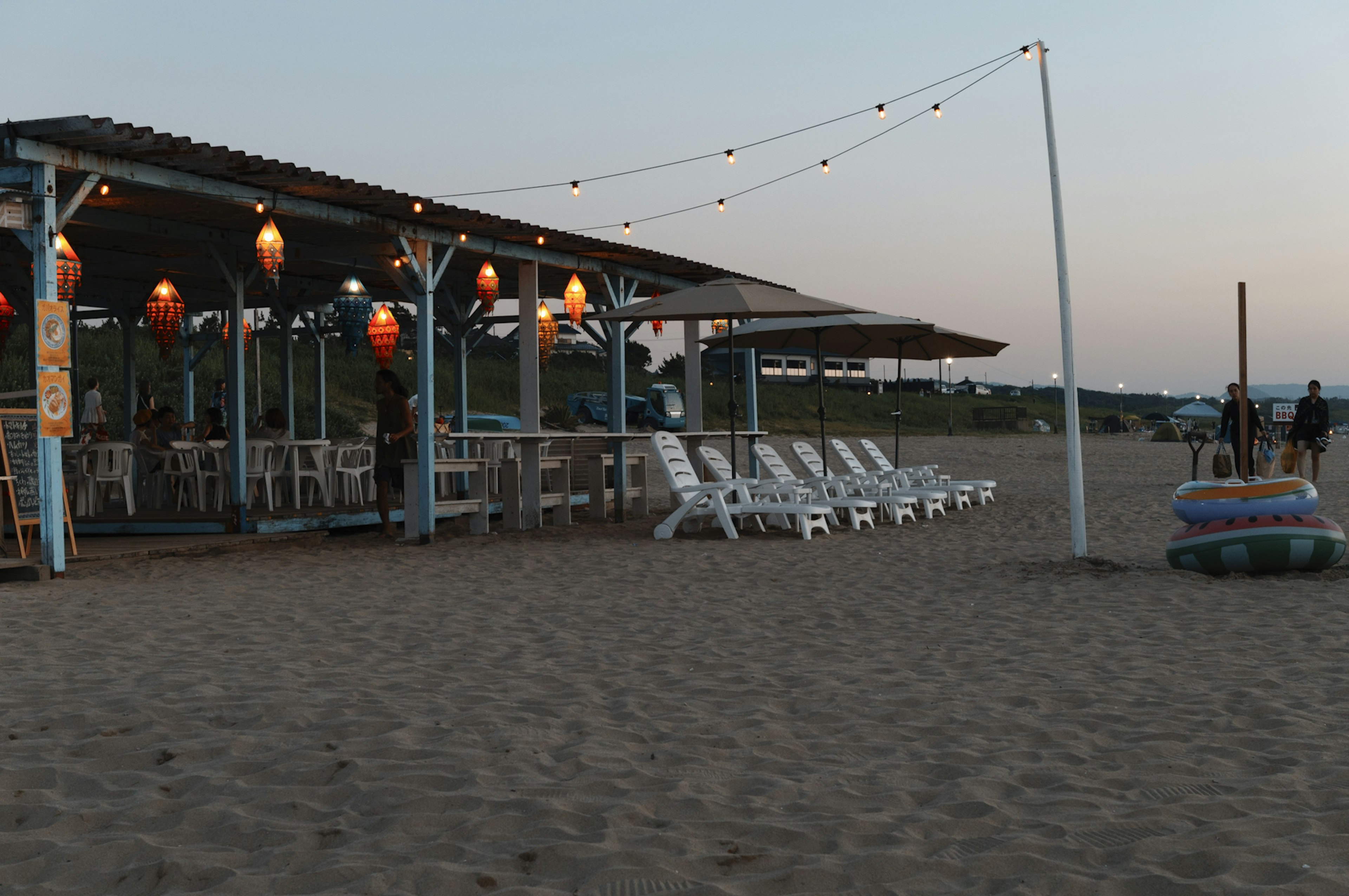 Restoran tepi pantai dengan kursi pantai putih di pasir