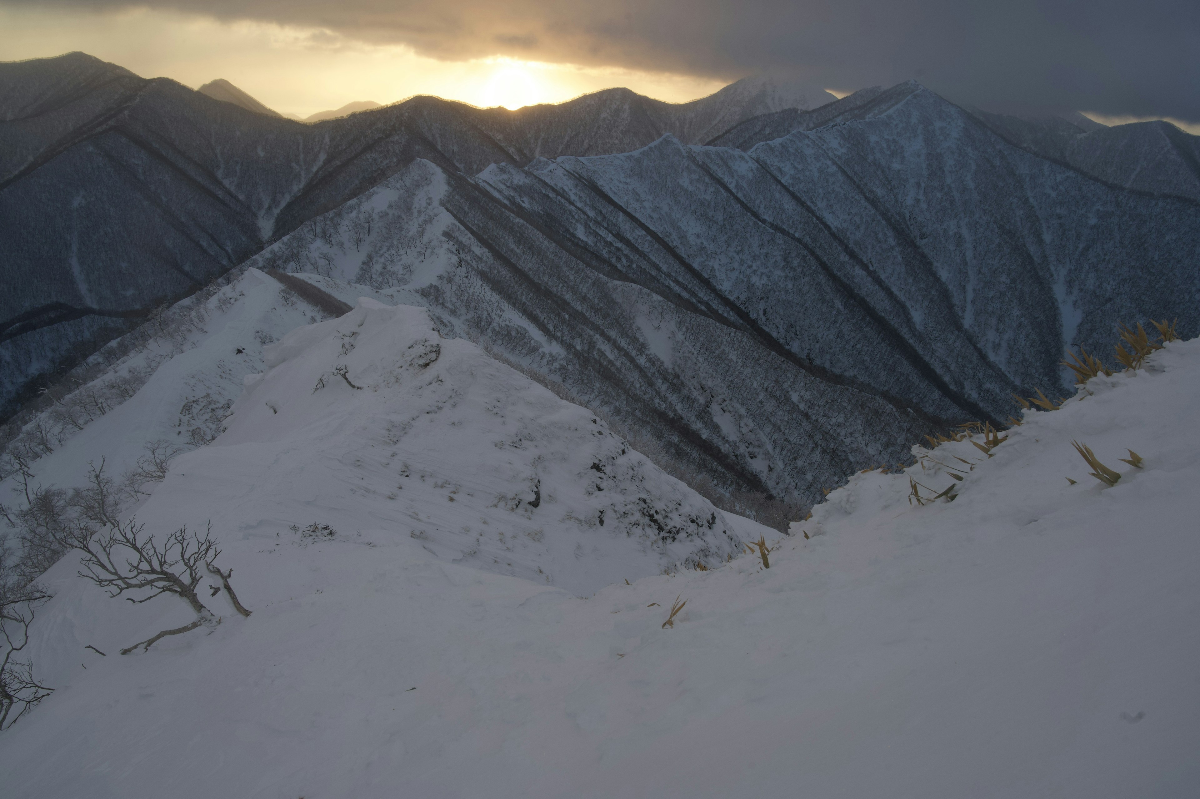 Schneebedeckte Berglandschaft mit Sonnenunterganglicht