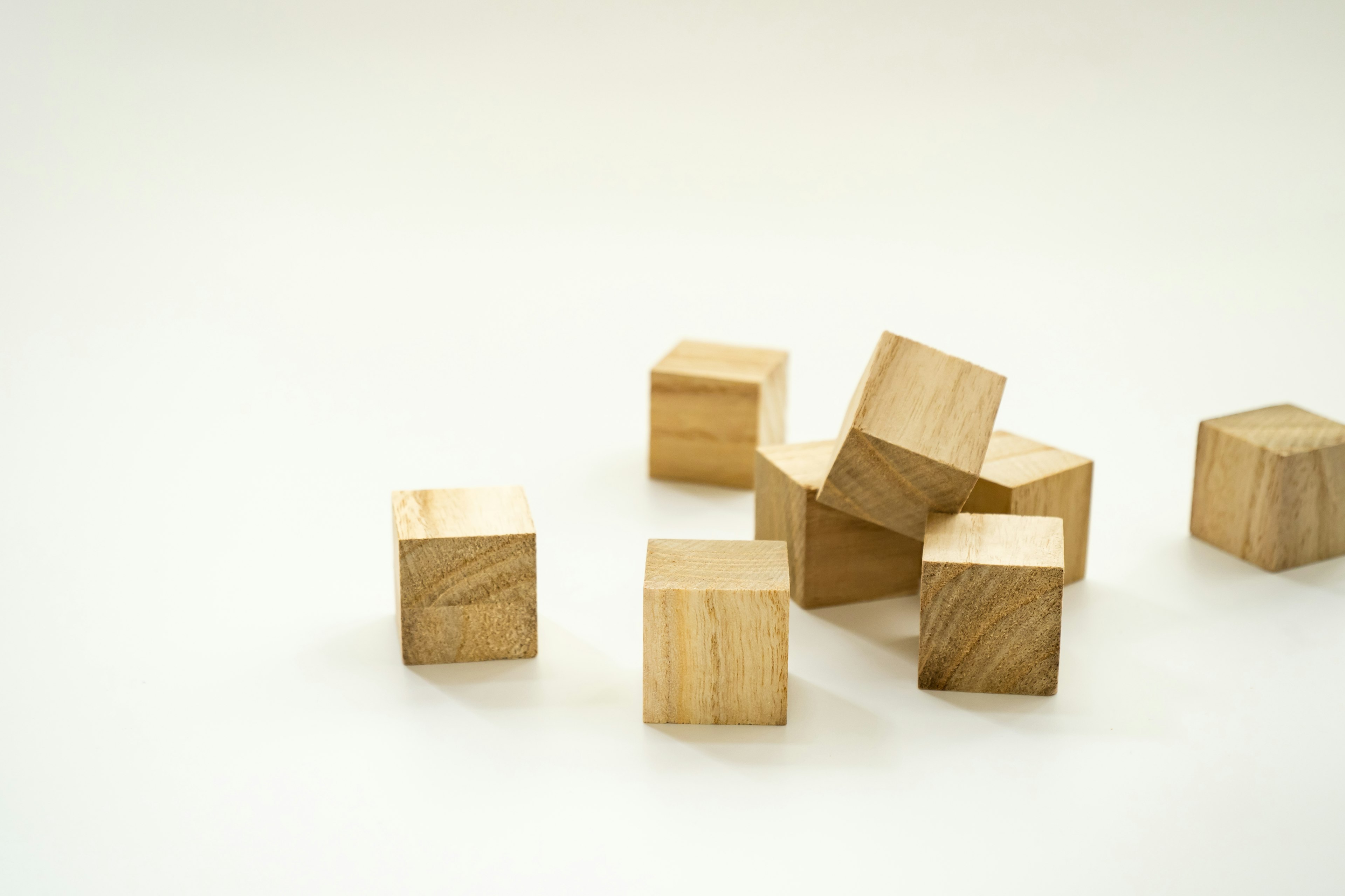 Une collection de cubes en bois disposés de manière aléatoire sur un fond simple