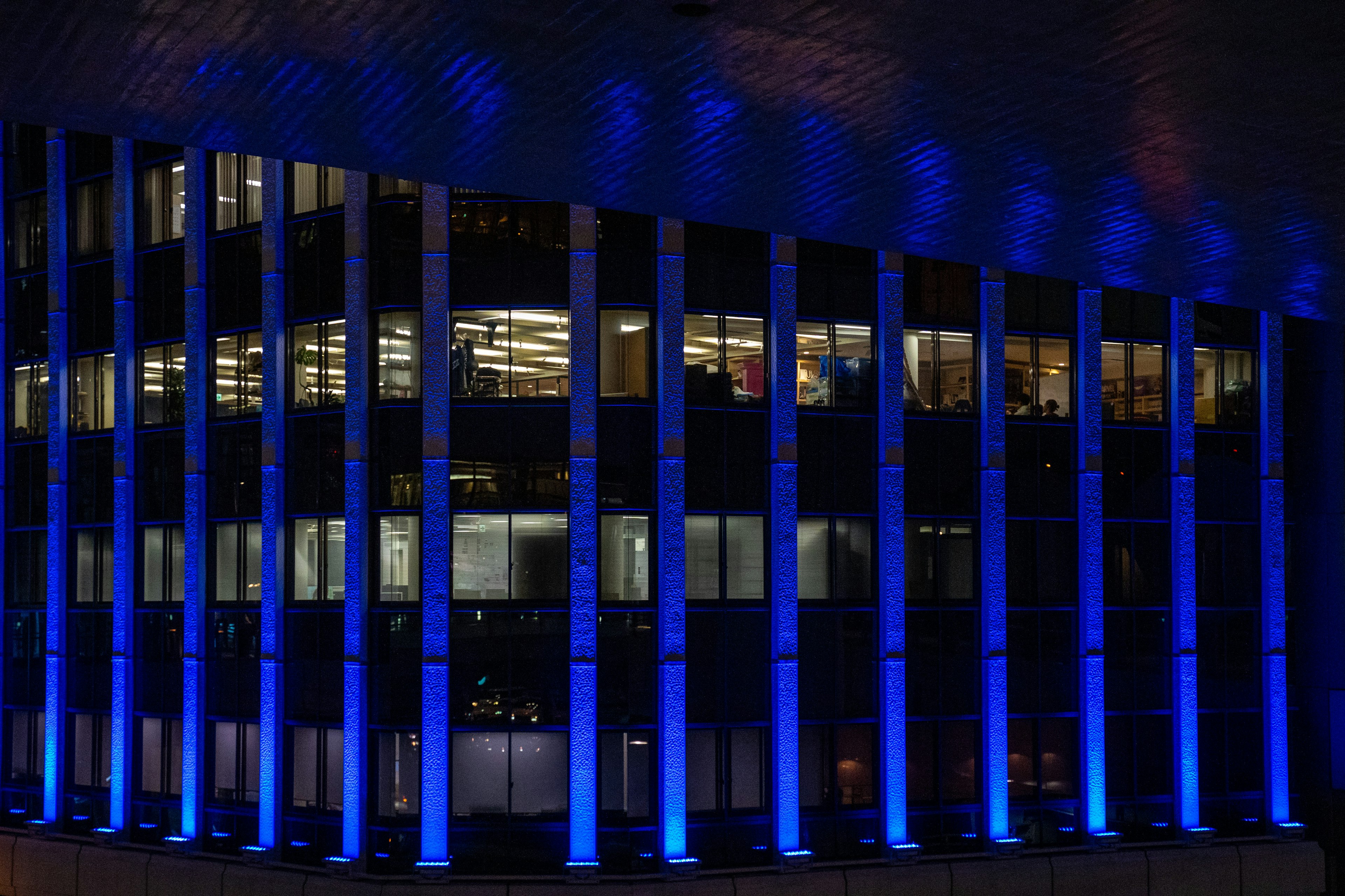 Office building exterior highlighted by blue lighting