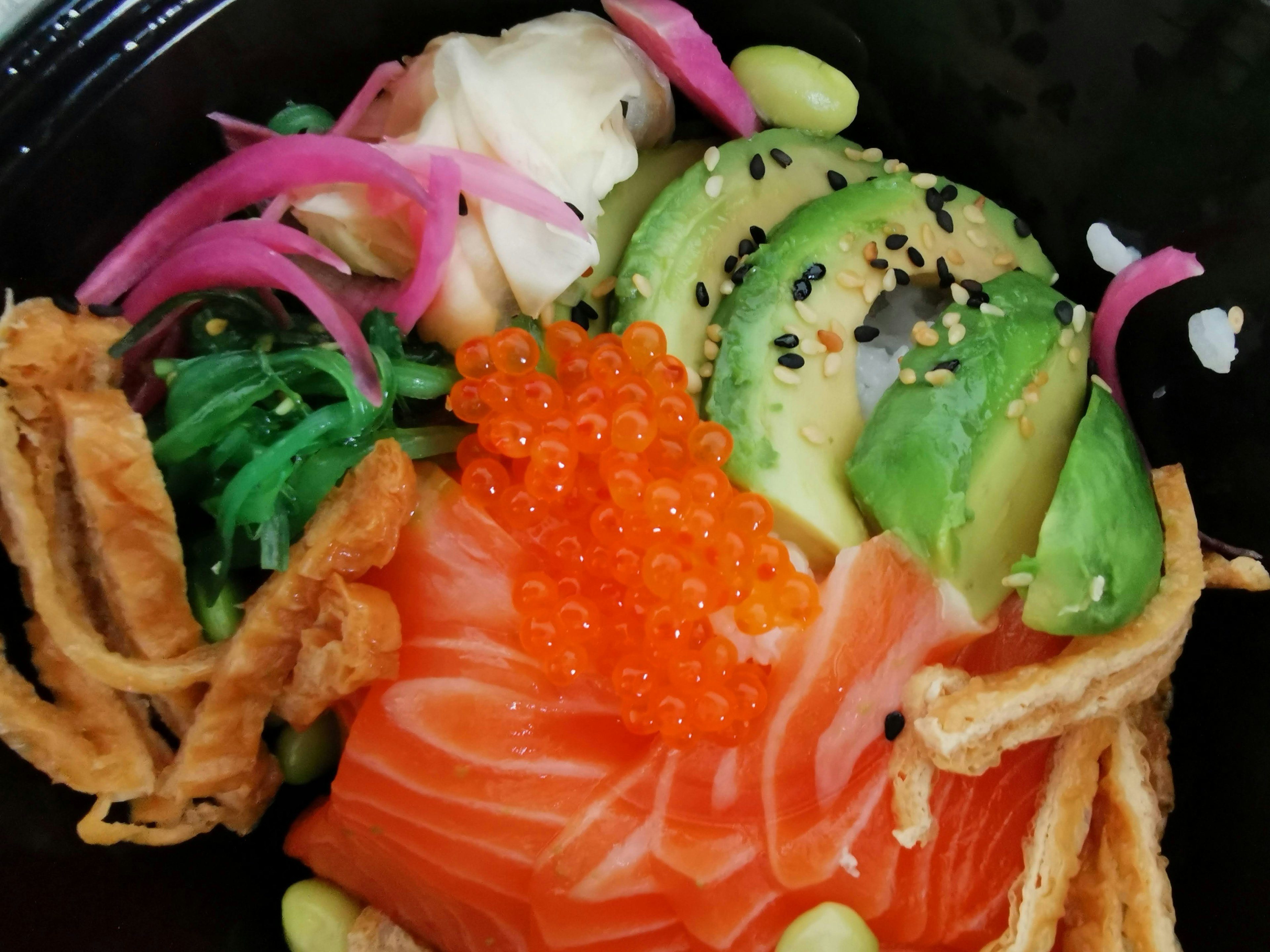 Tazón de salmón con aguacate, algas, huevas de salmón y coberturas crujientes