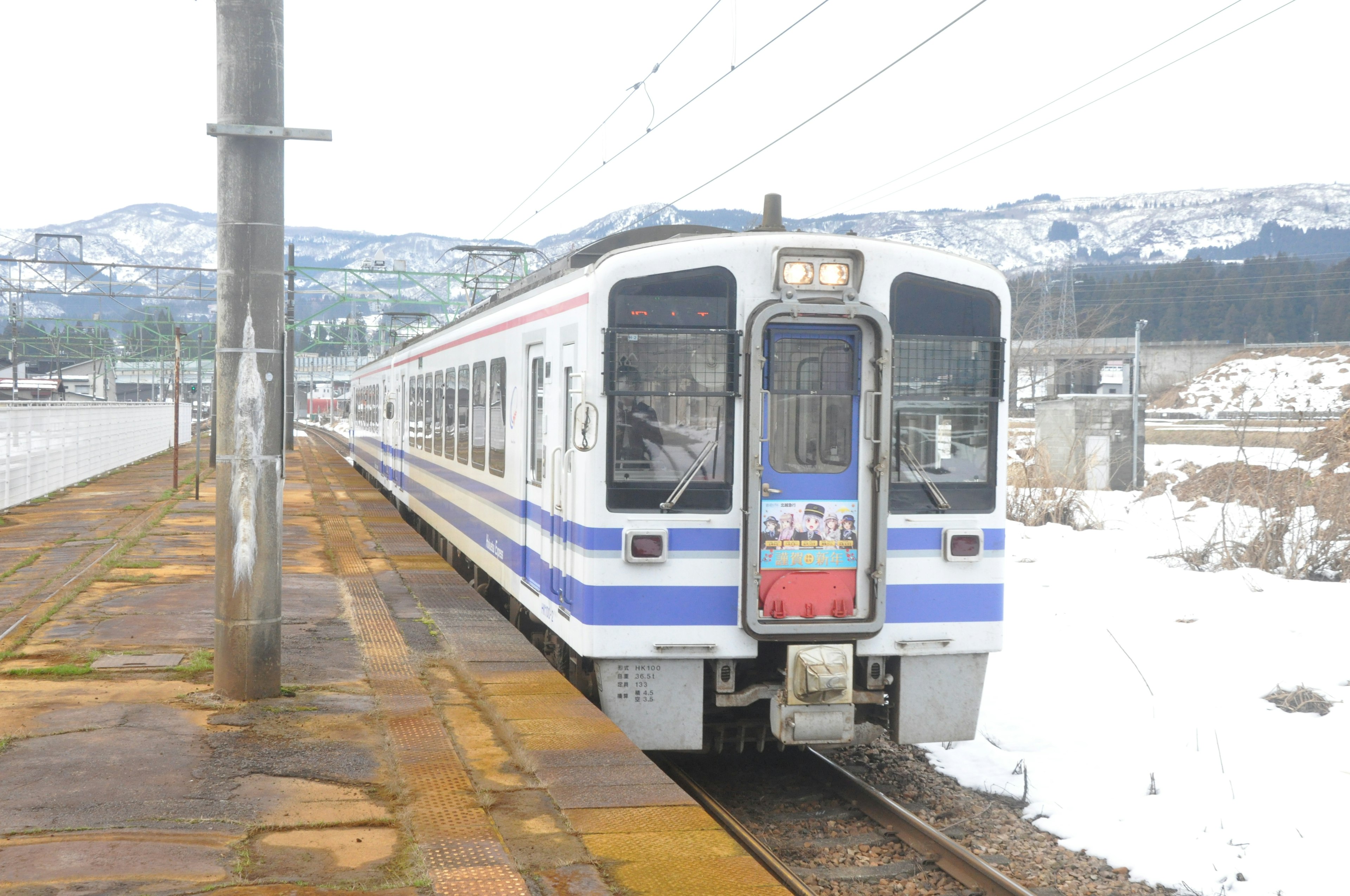 Blue and white train stopped in a snowy landscape