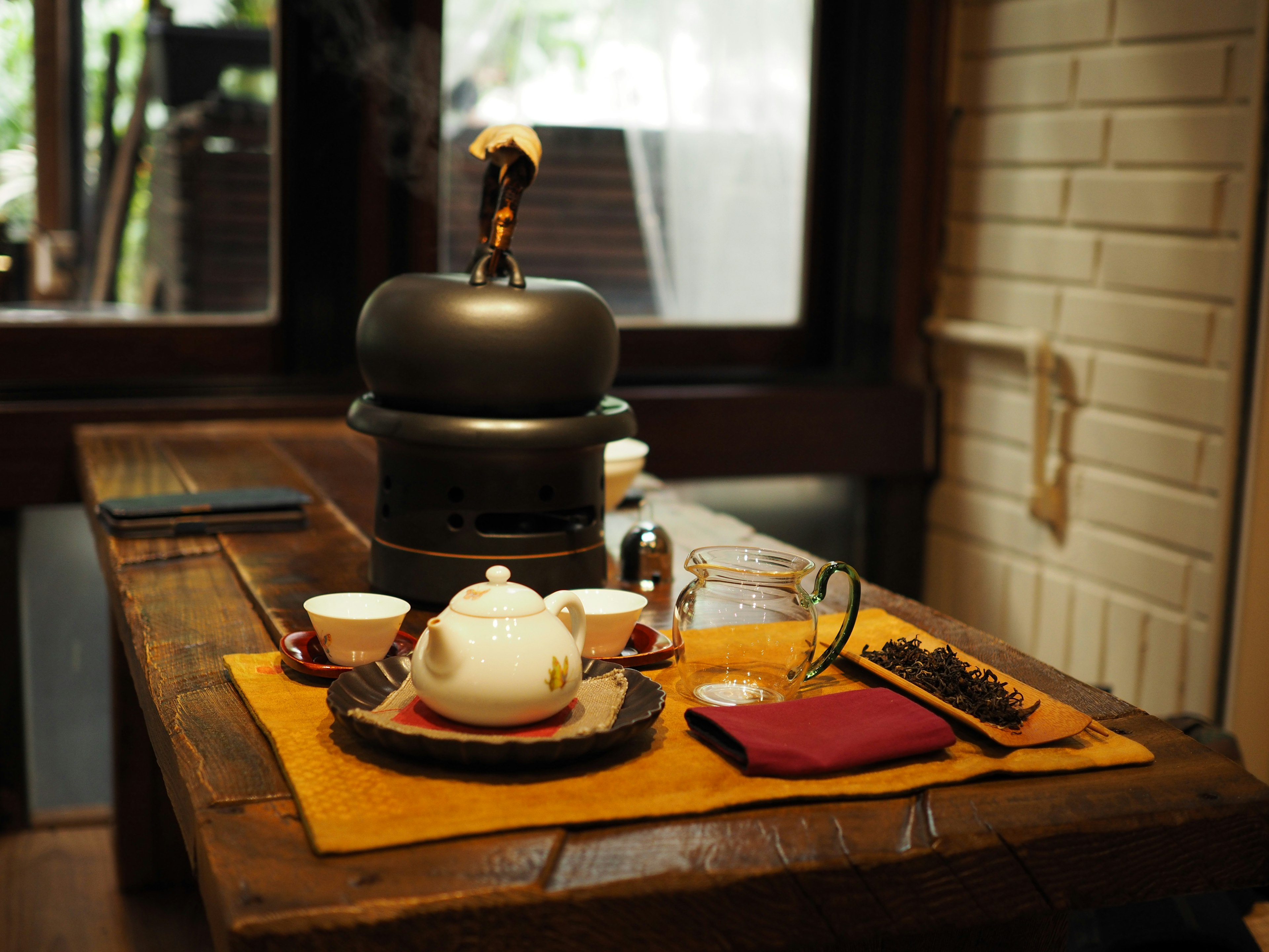 Tea set arranged on a wooden table with traditional tea utensils