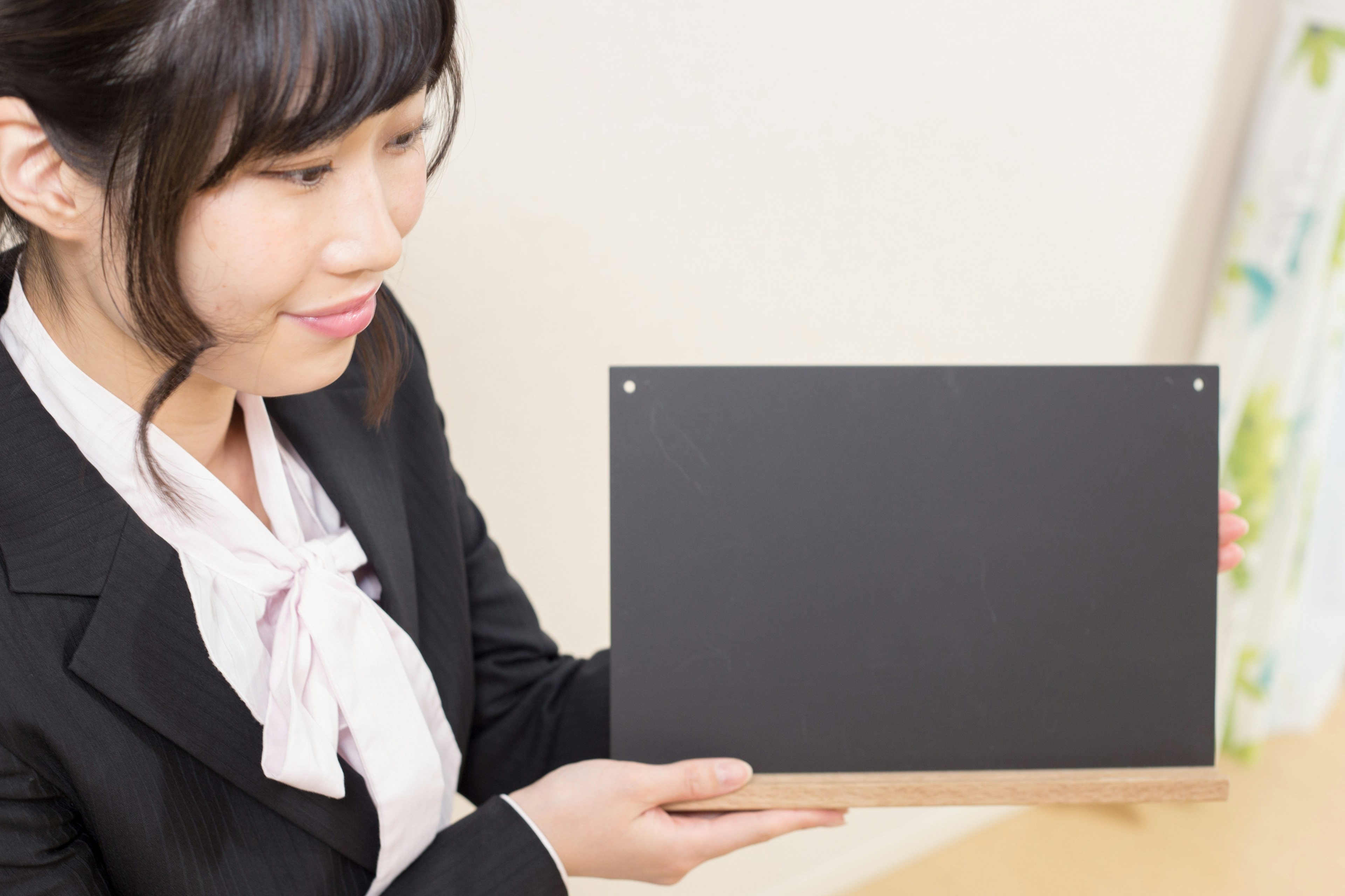 A woman holding a black board in a business setting