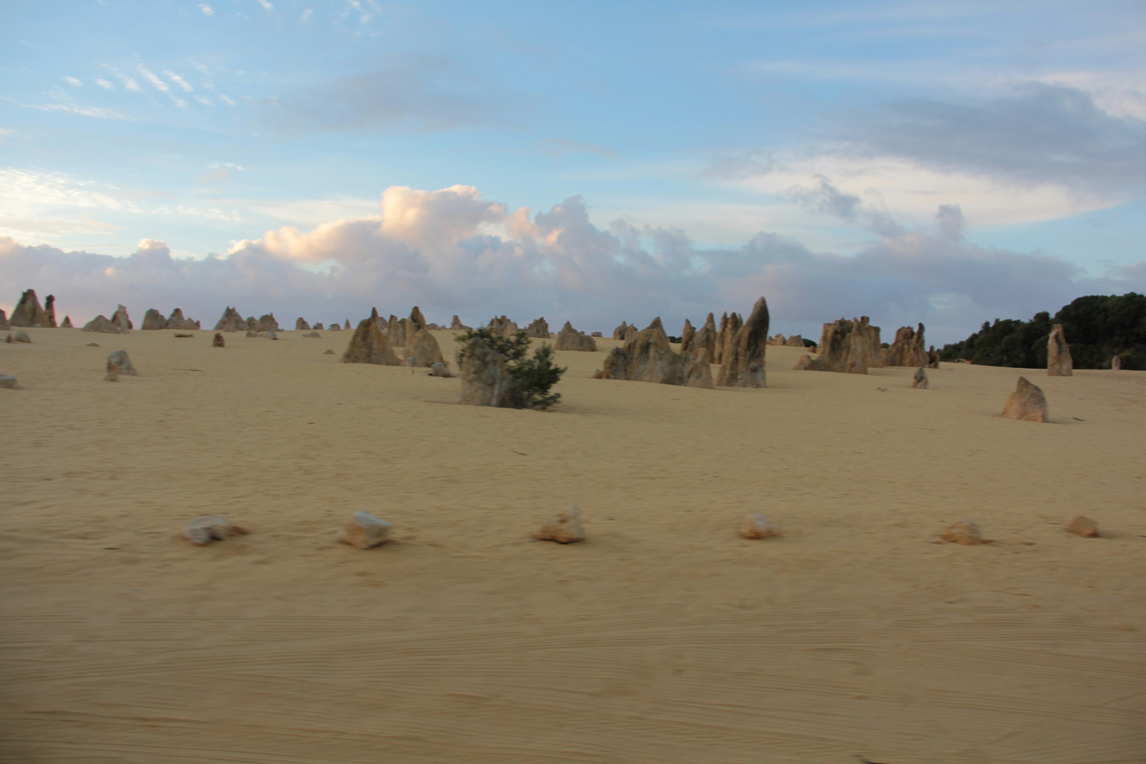 Expansive desert landscape with scattered rock formations and blue sky