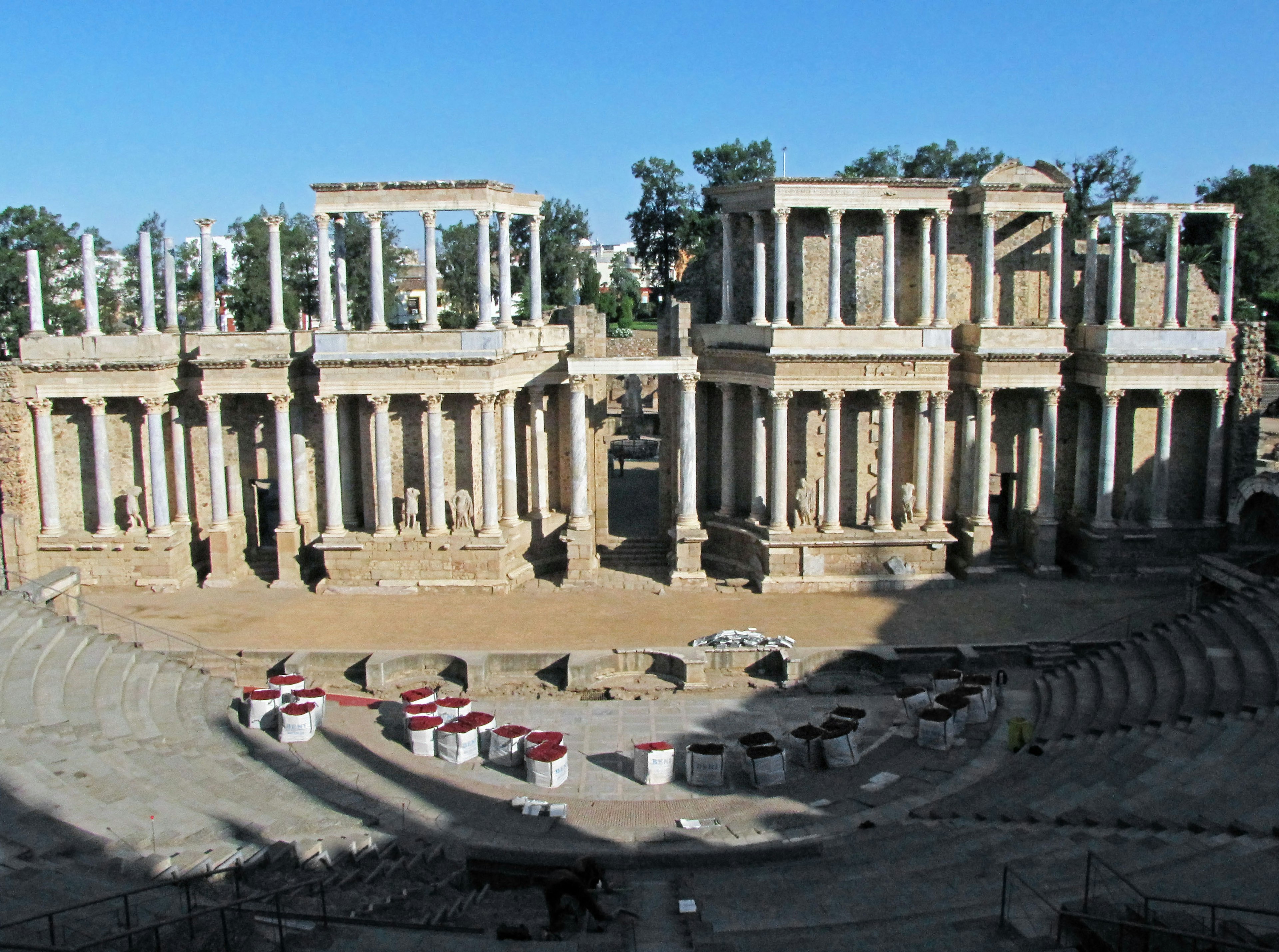 Grand architectural ruins of an ancient theater under a blue sky