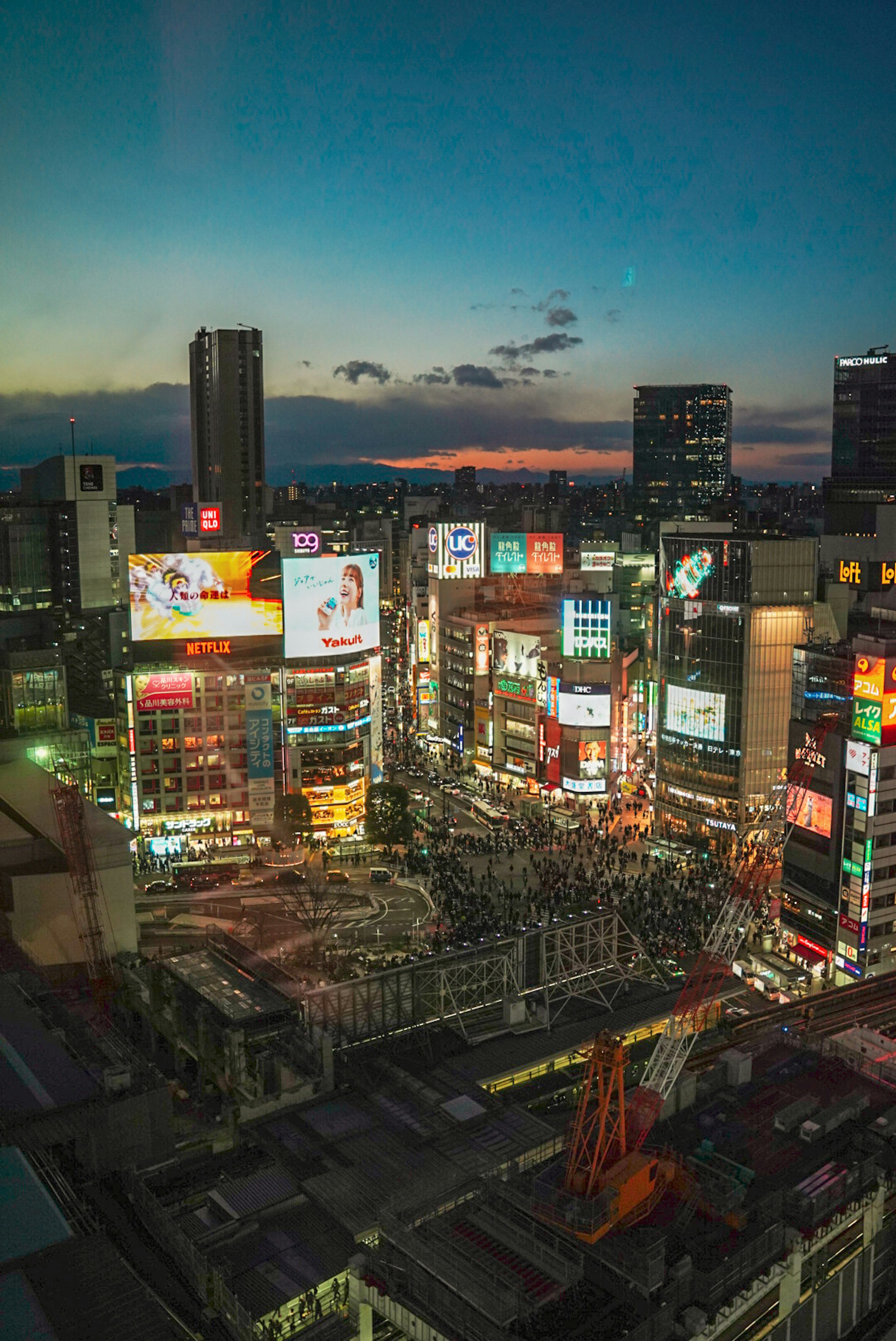 Stadtbild von Shibuya bei Dämmerung mit Neonreklamen