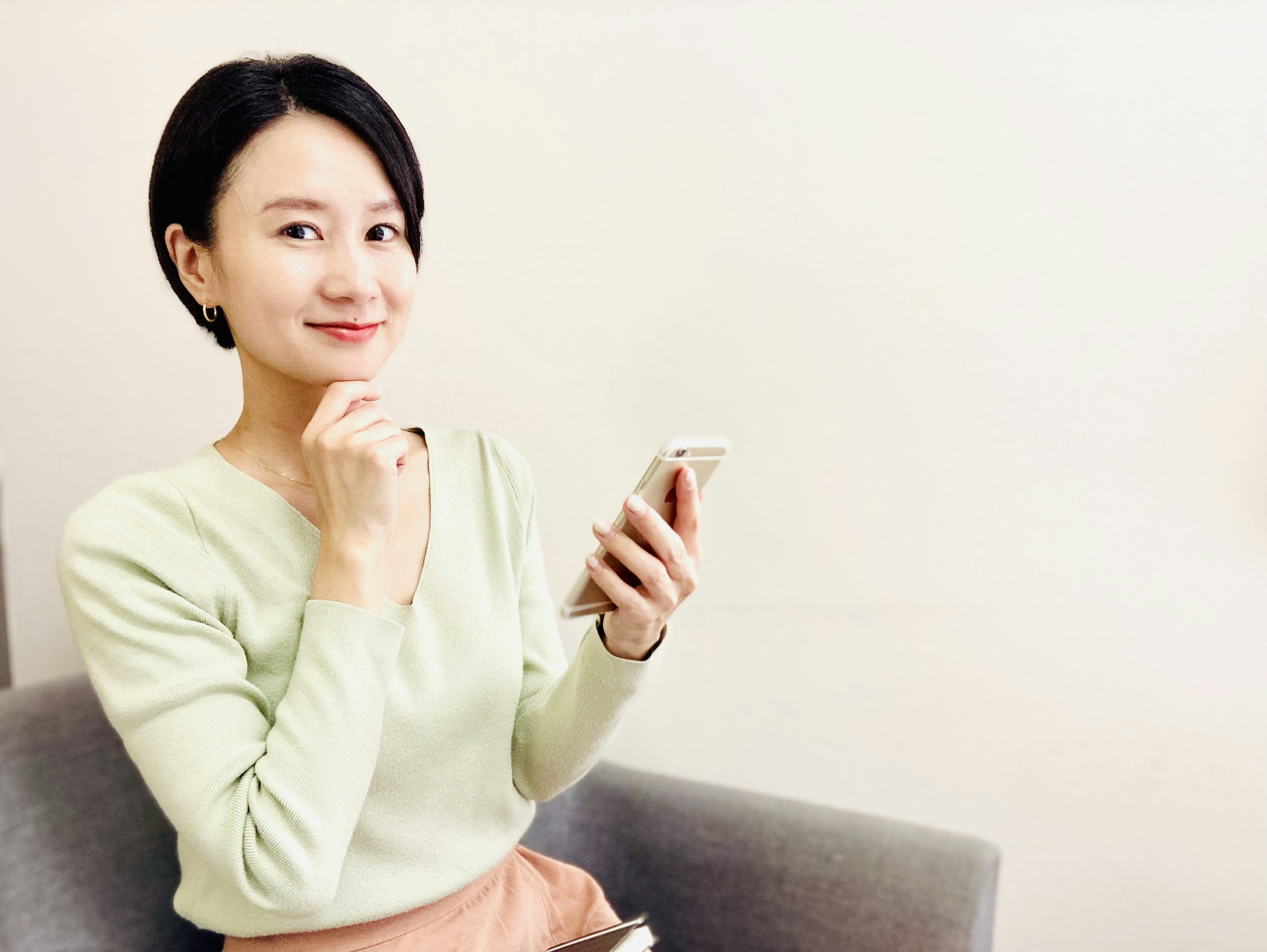 Young woman holding a smartphone with a thoughtful expression