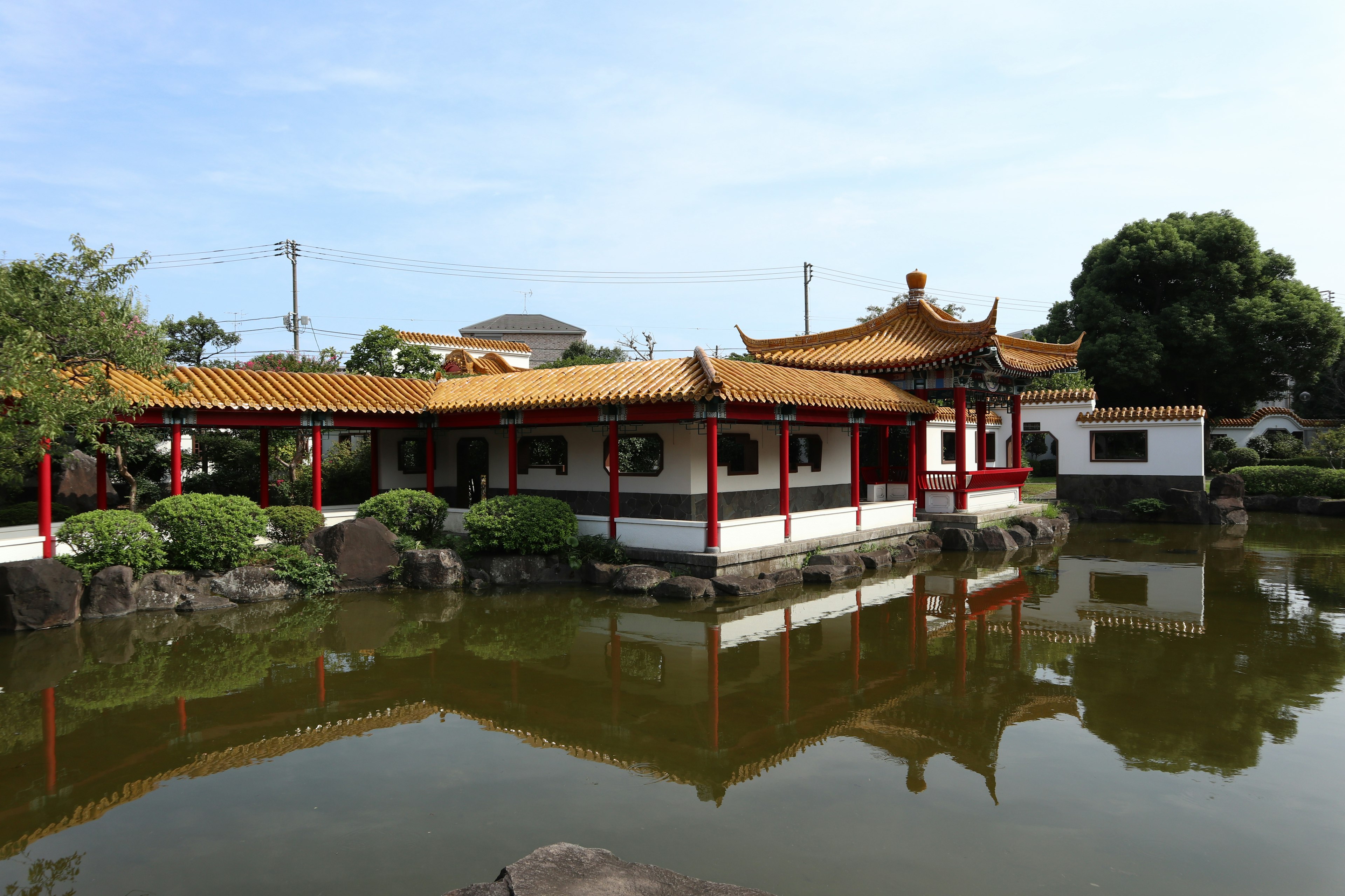 Bangunan bergaya Cina tradisional di tepi kolam tenang