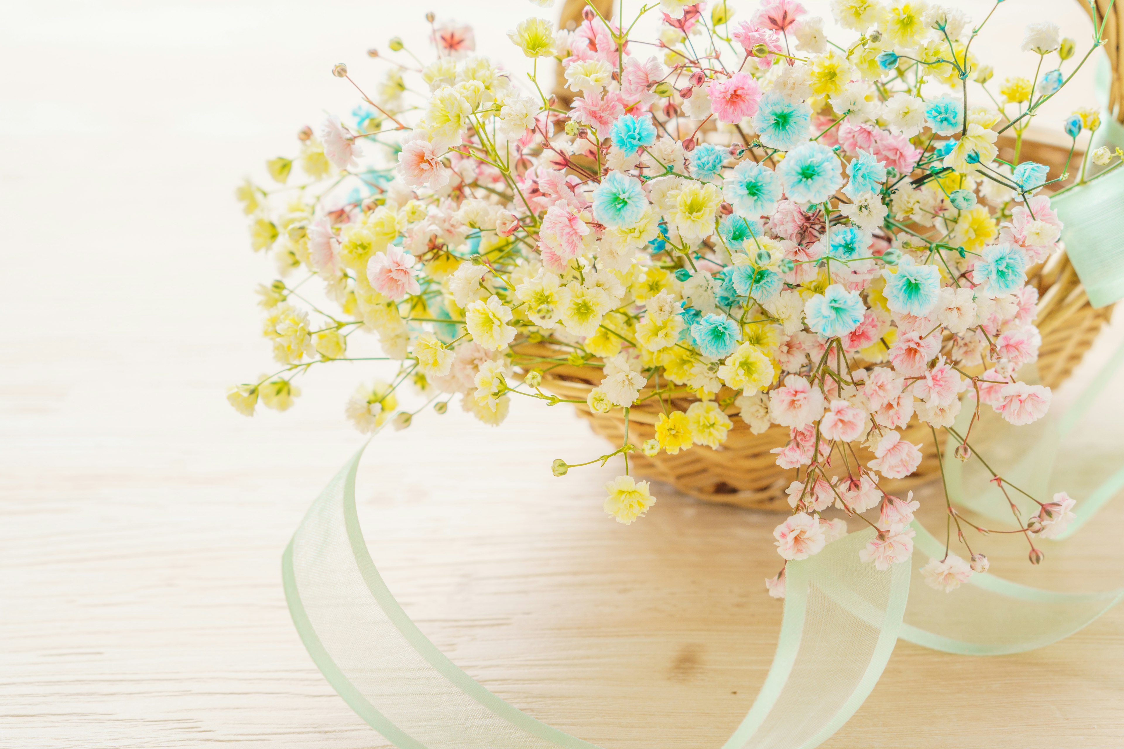 Una bella disposizione di piccoli fiori colorati in un cesto con un nastro