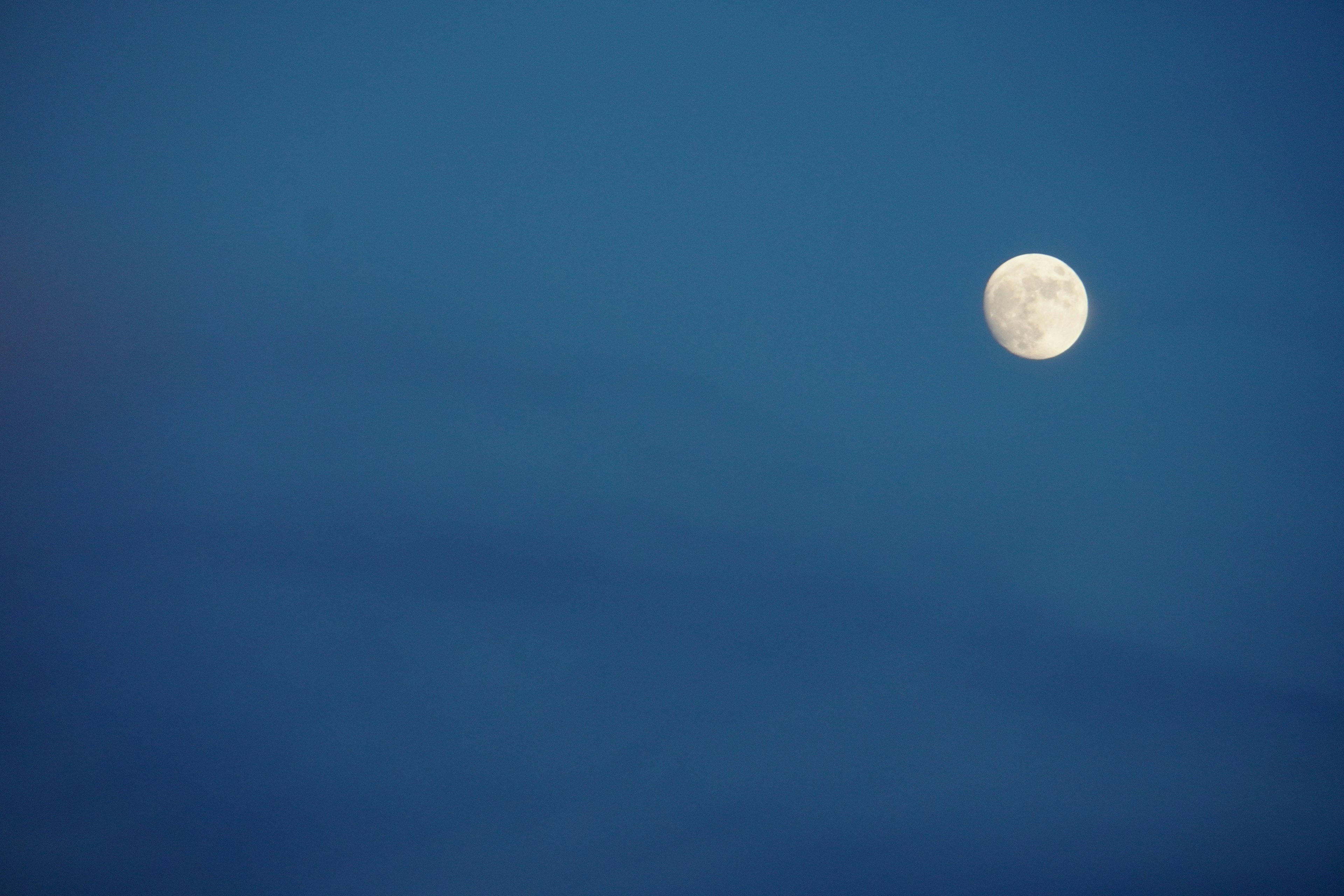 Full moon floating in a blue sky