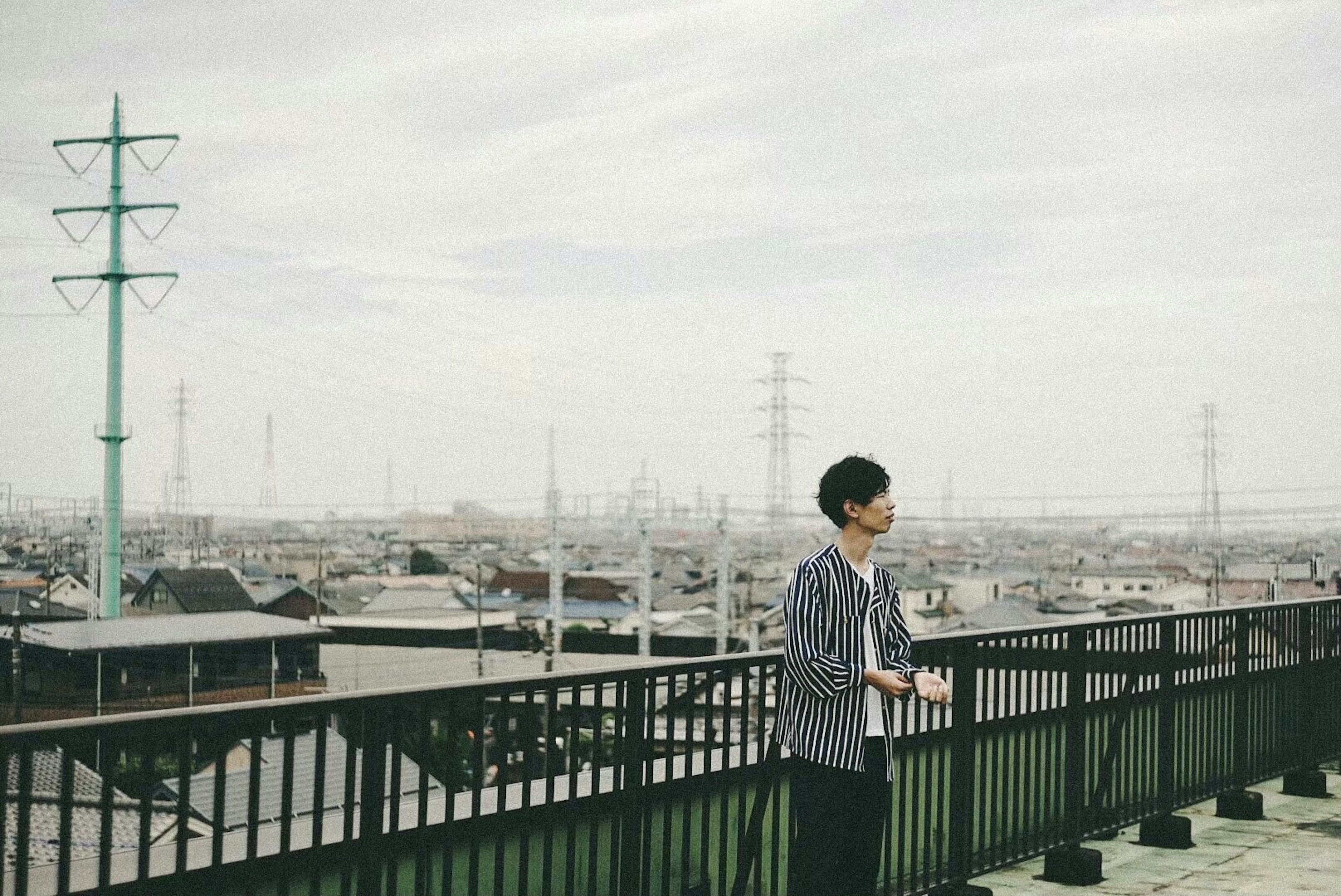 Man standing on a rooftop with a cityscape background