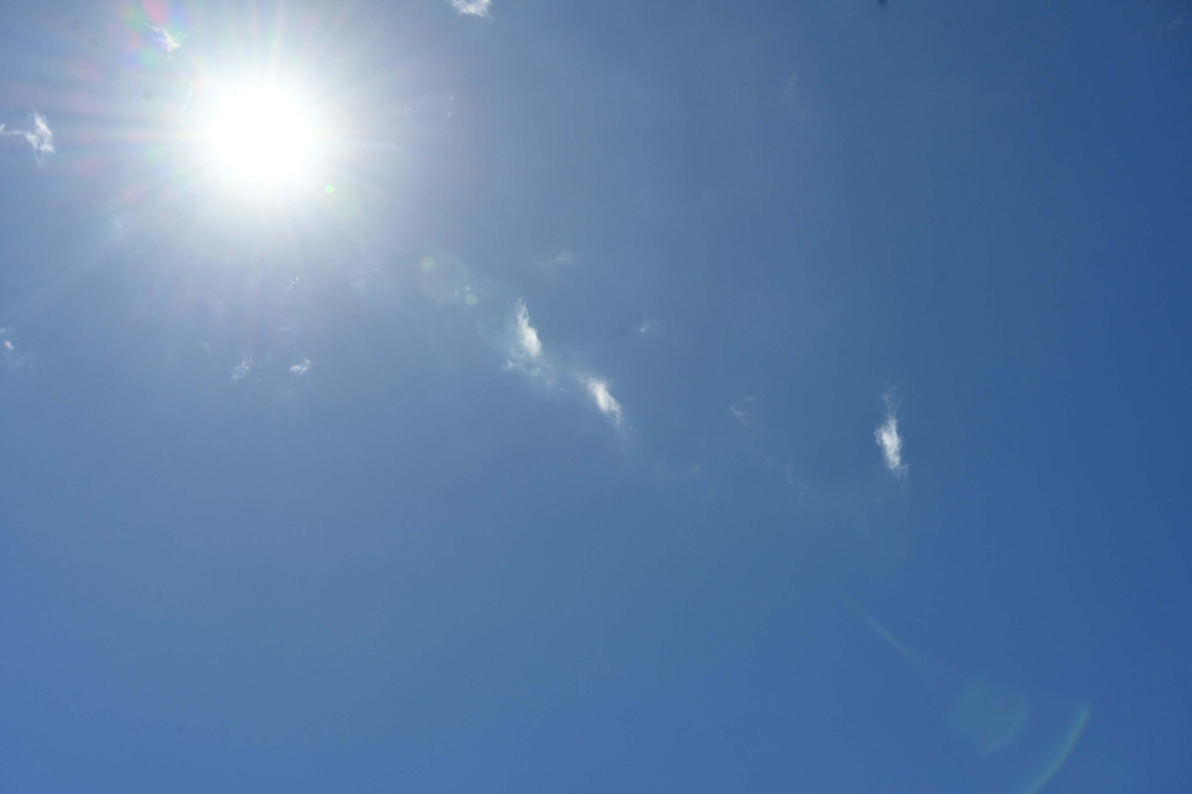 青空に輝く太陽と薄い雲の様子