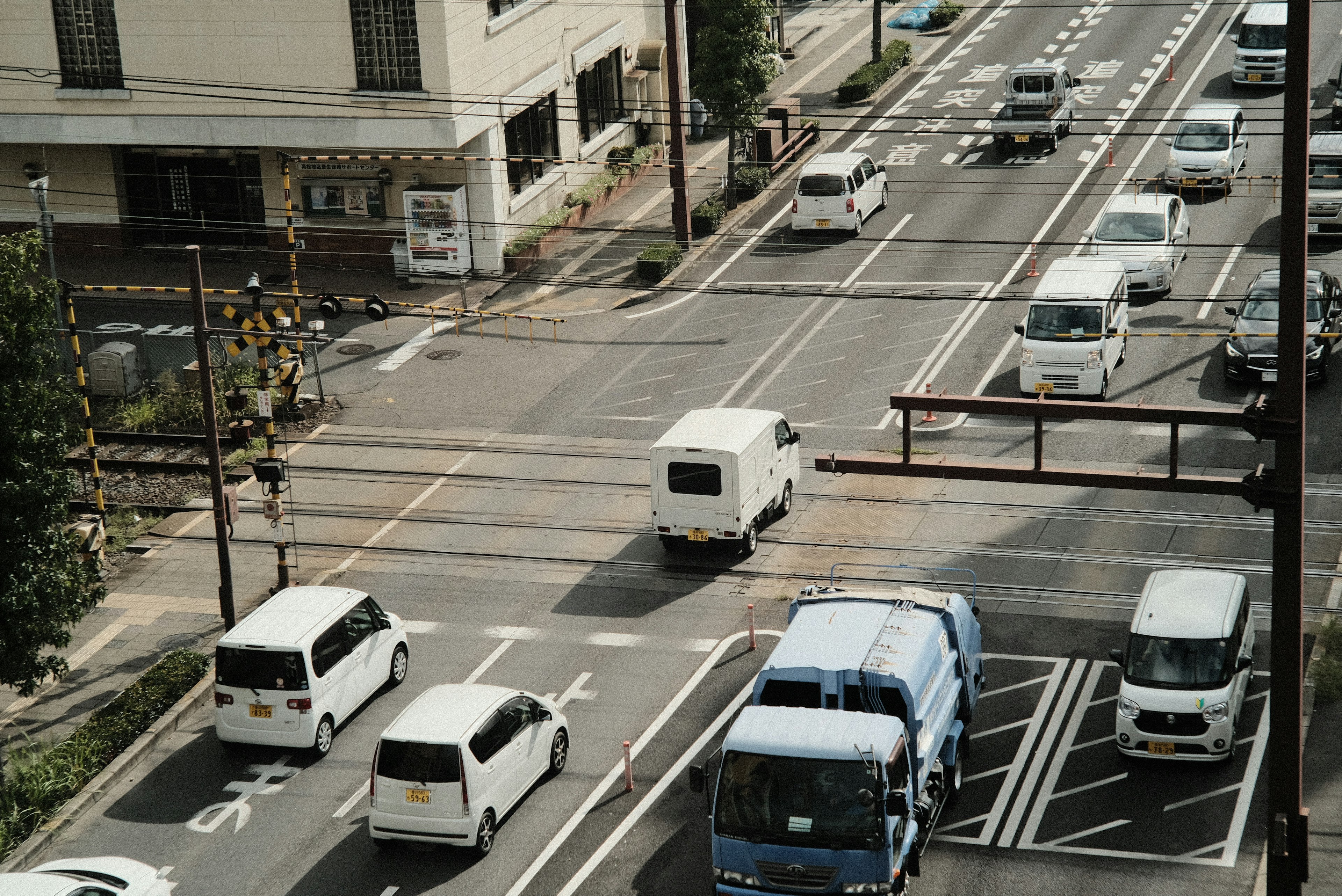 Urban scene showing a white van at an intersection with various vehicles on the road