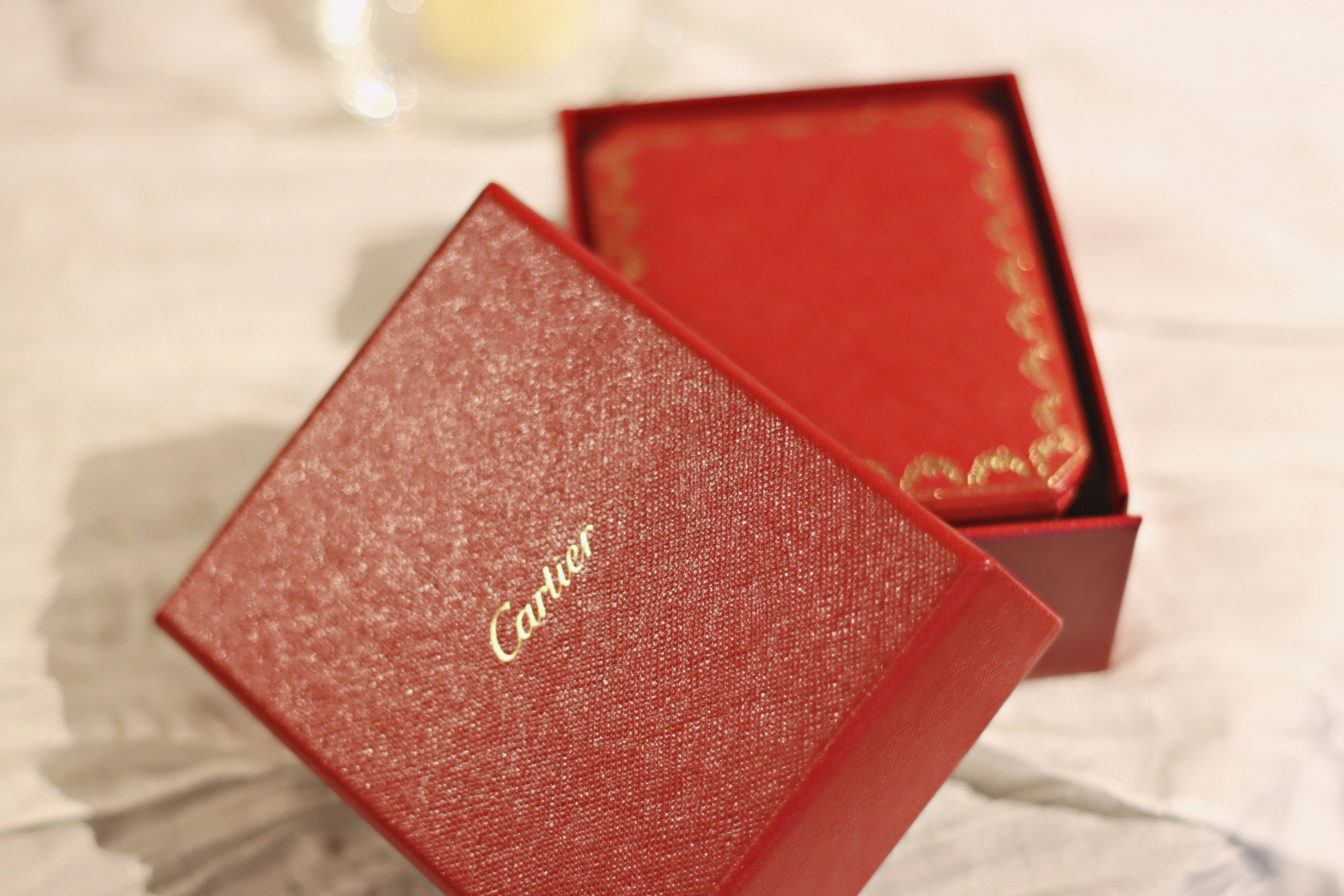 Eine luxuriöse rote Box, teilweise geöffnet, mit dem Cartier-Logo