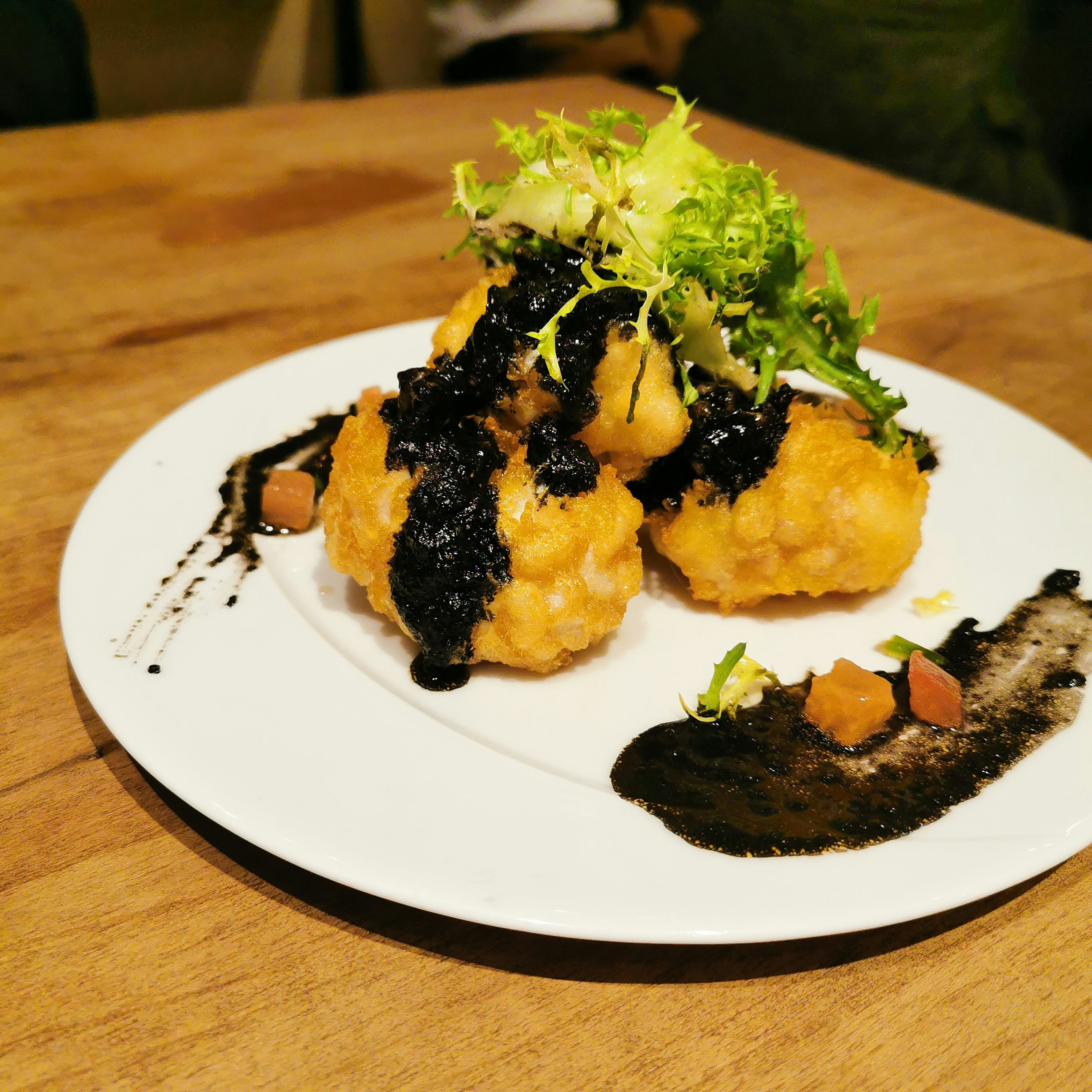 Plat frit servi avec une sauce noire et une garniture de légumes