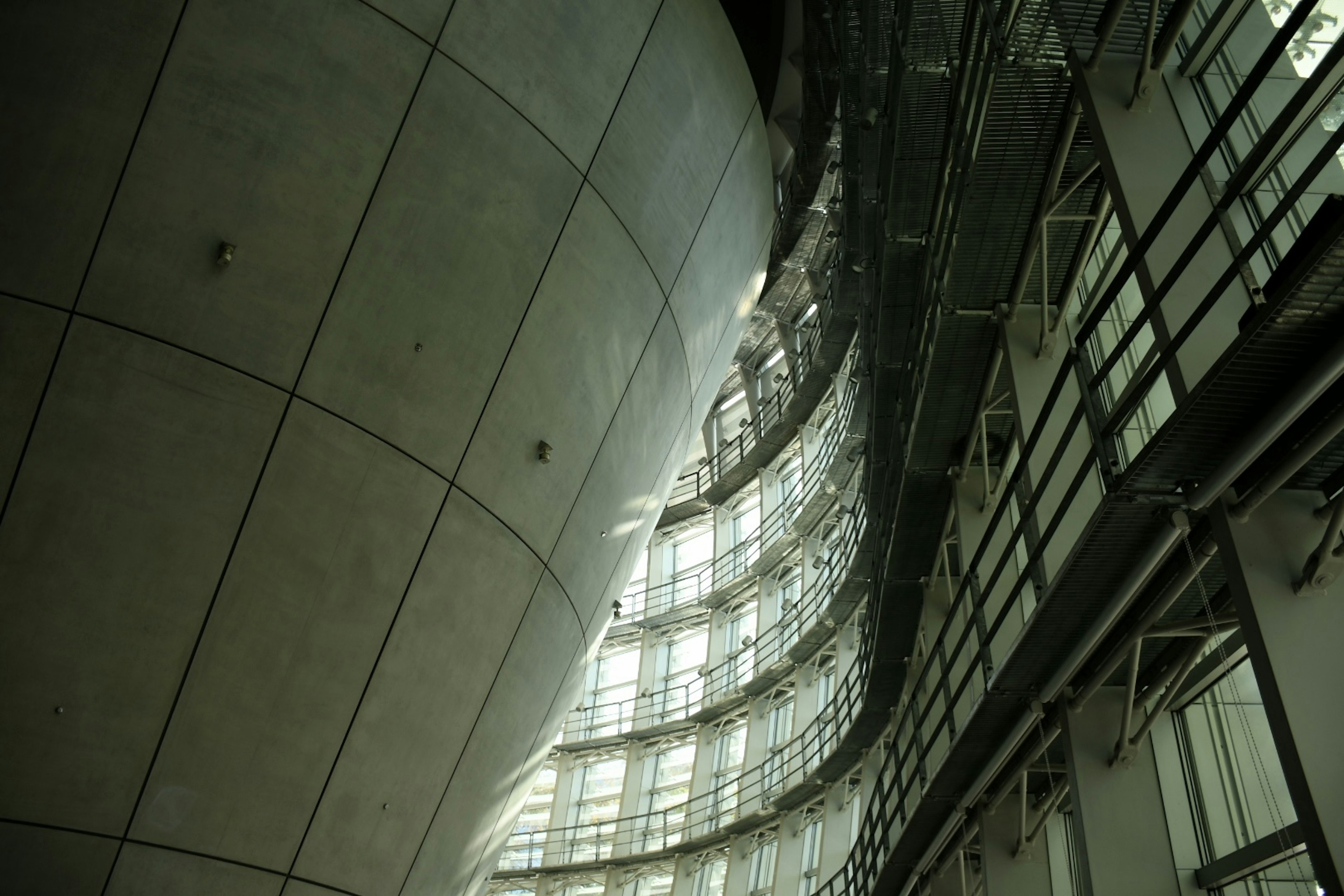 Intérieur d'une architecture moderne avec un mur en béton courbé et une structure en verre