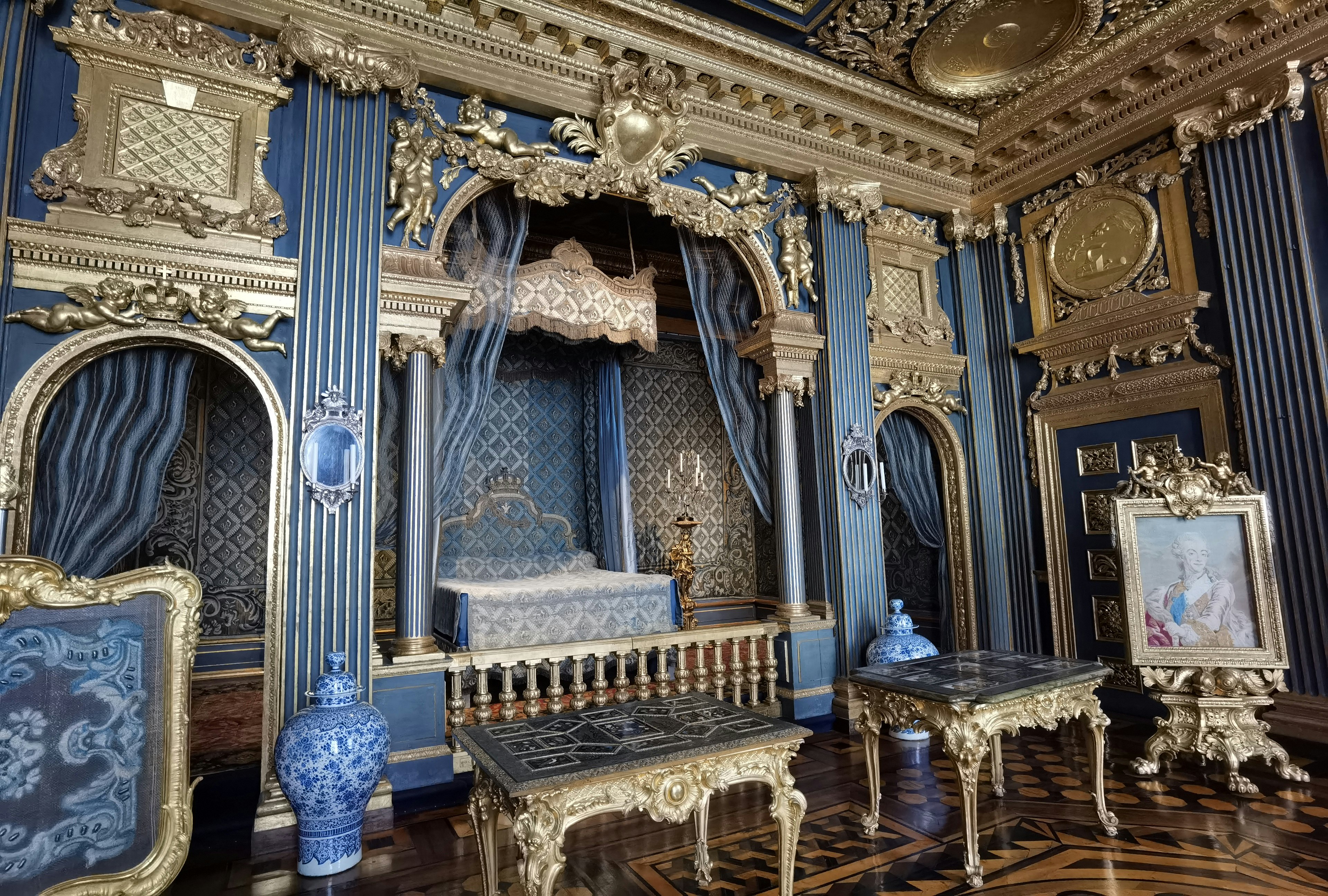 Luxurious interior of a blue and gold room featuring ornate decorations and paintings