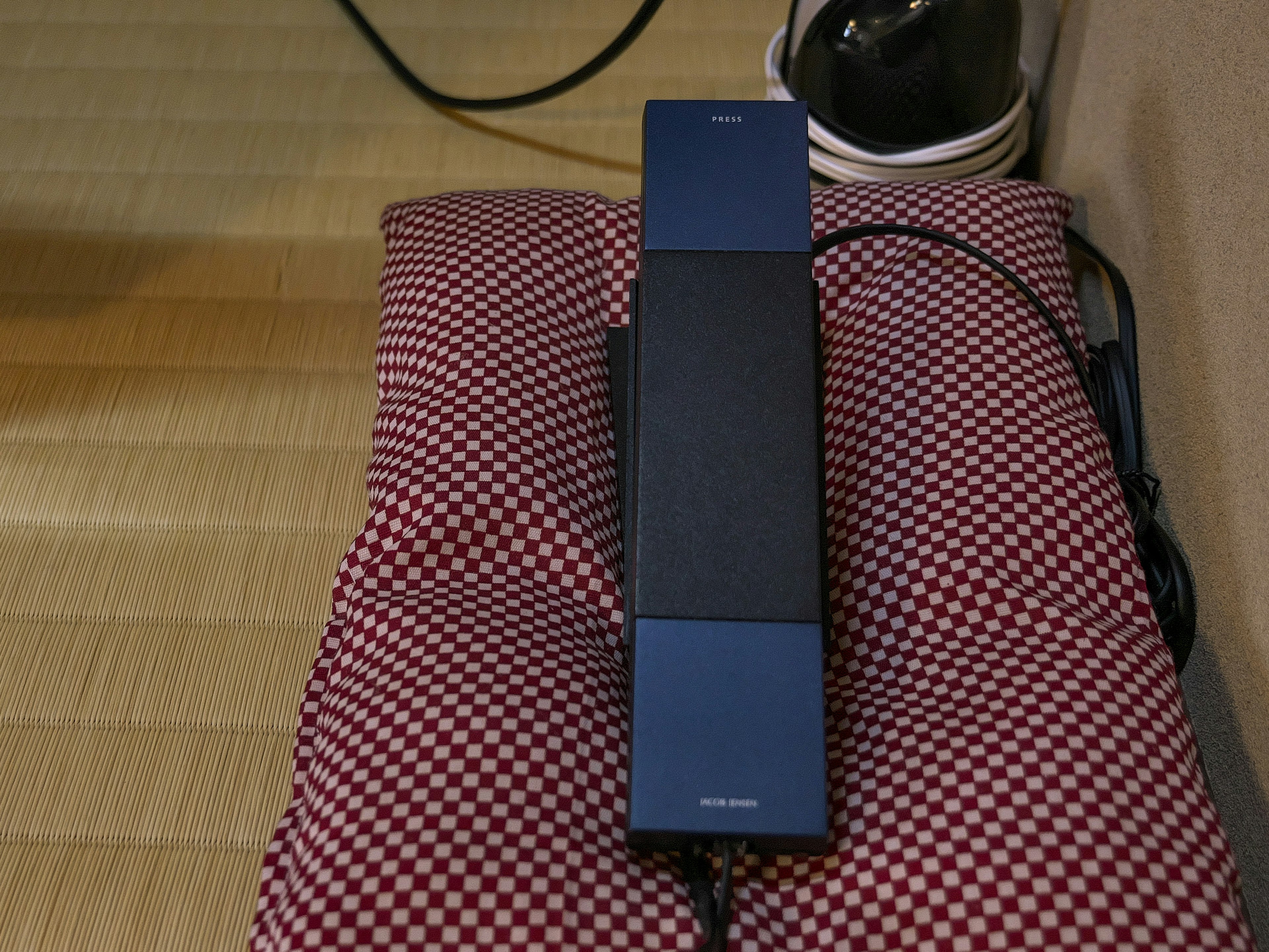 A blue device resting on a red checkered cushion