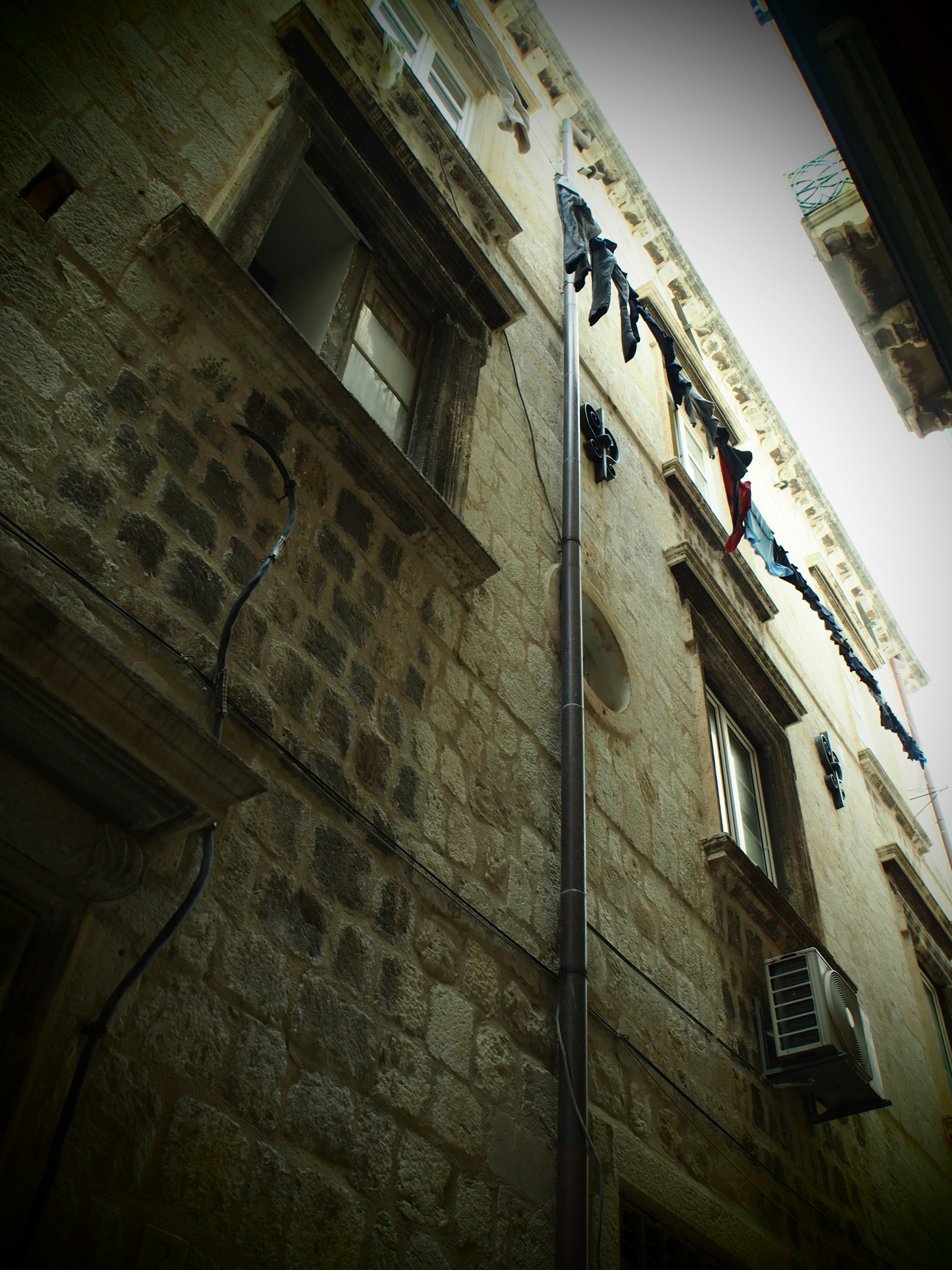 Mur d'un vieux bâtiment en pierre avec du linge suspendu