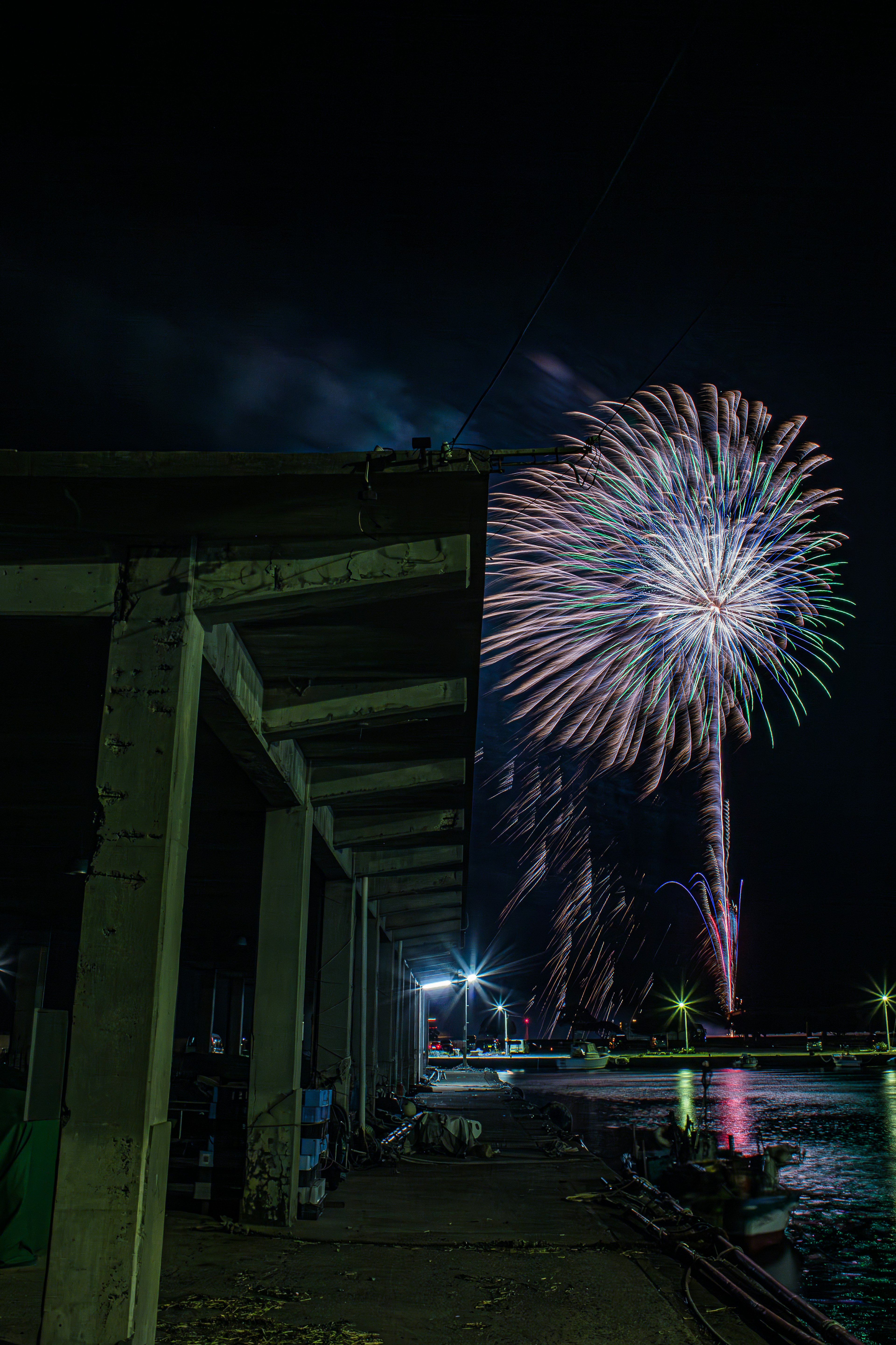 Feu d'artifice coloré au-dessus d'un quai la nuit