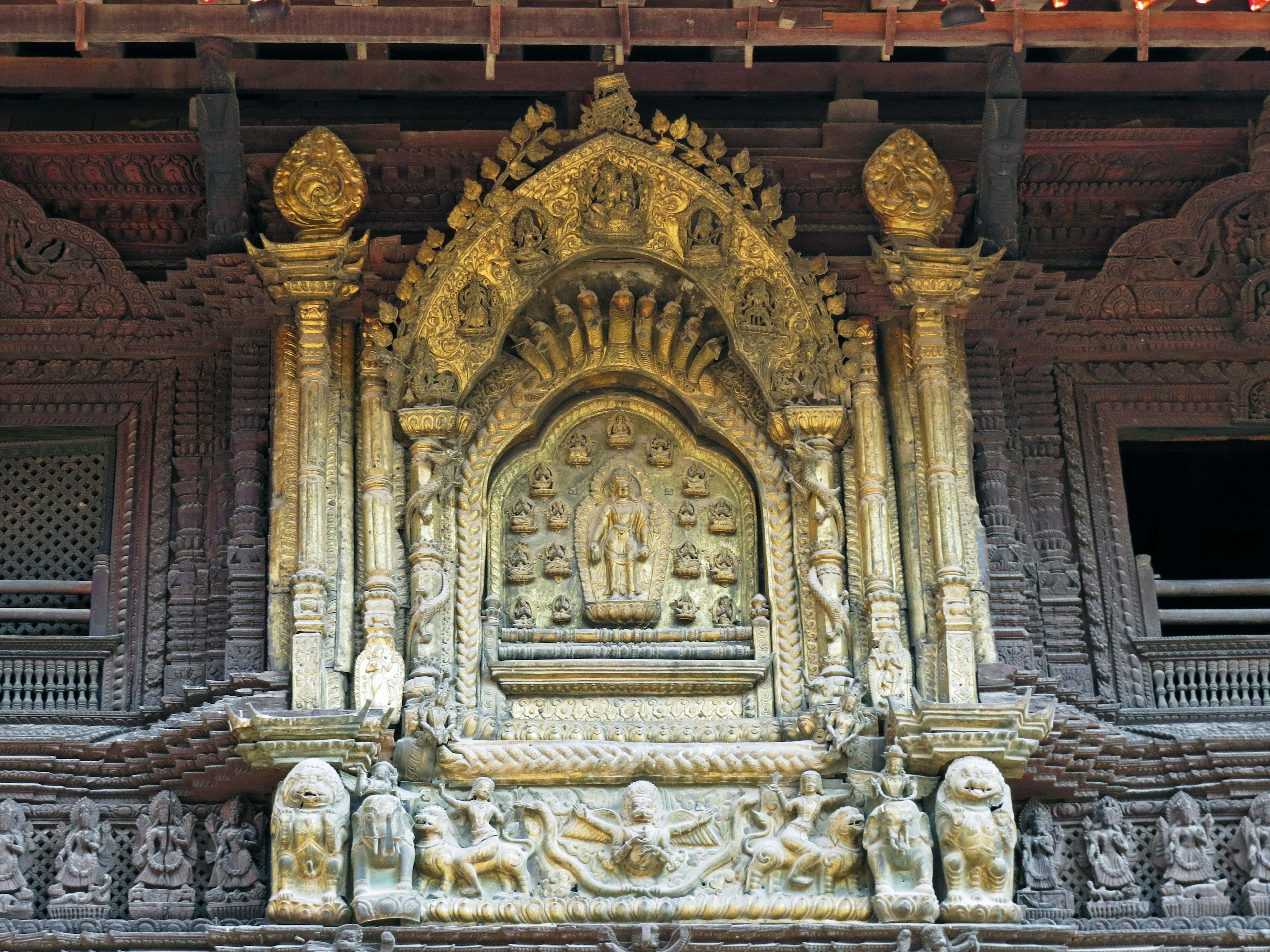 Intricate carvings on a temple exterior featuring a Buddha statue and decorative elements