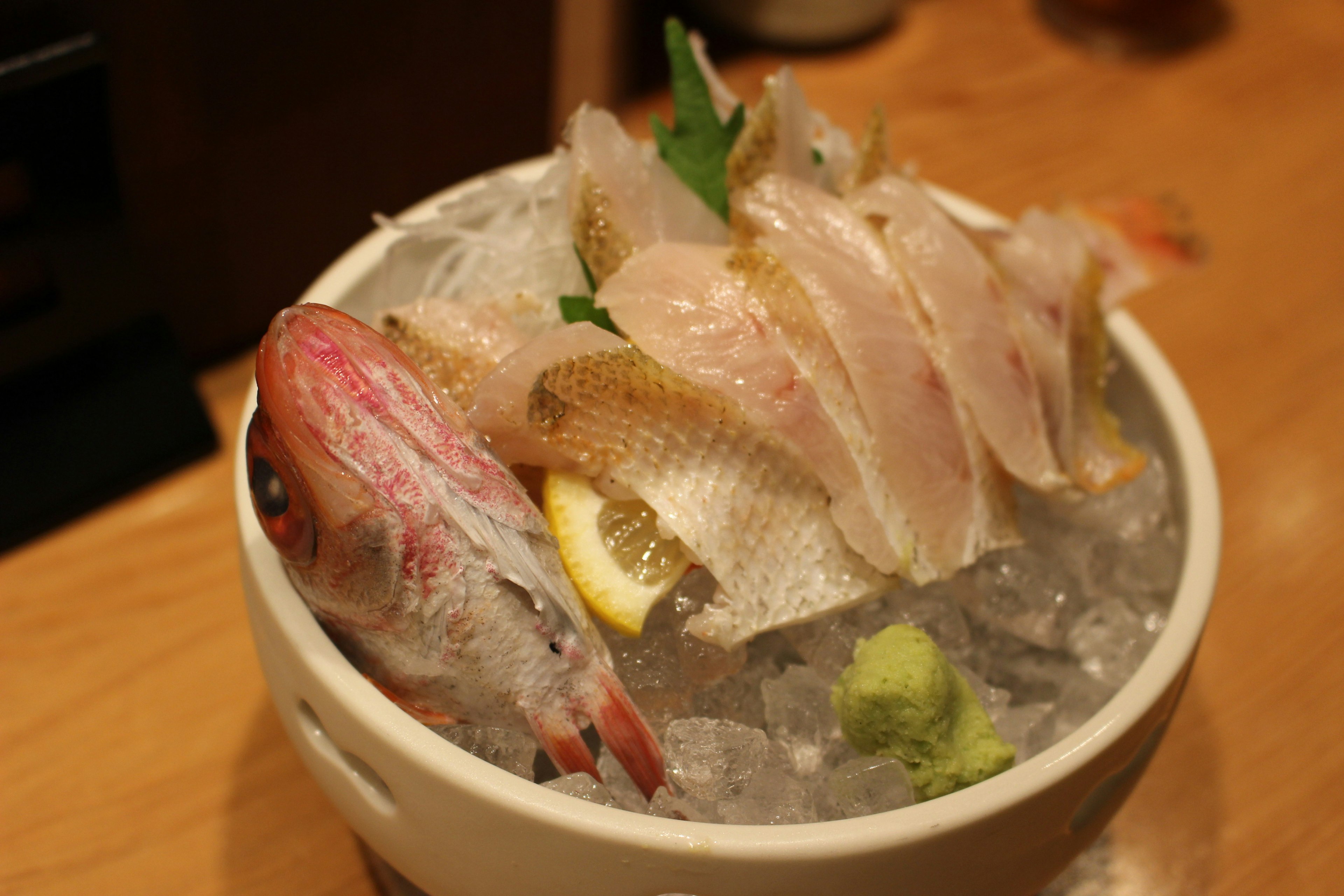 A bowl of fresh sashimi and fish served on ice