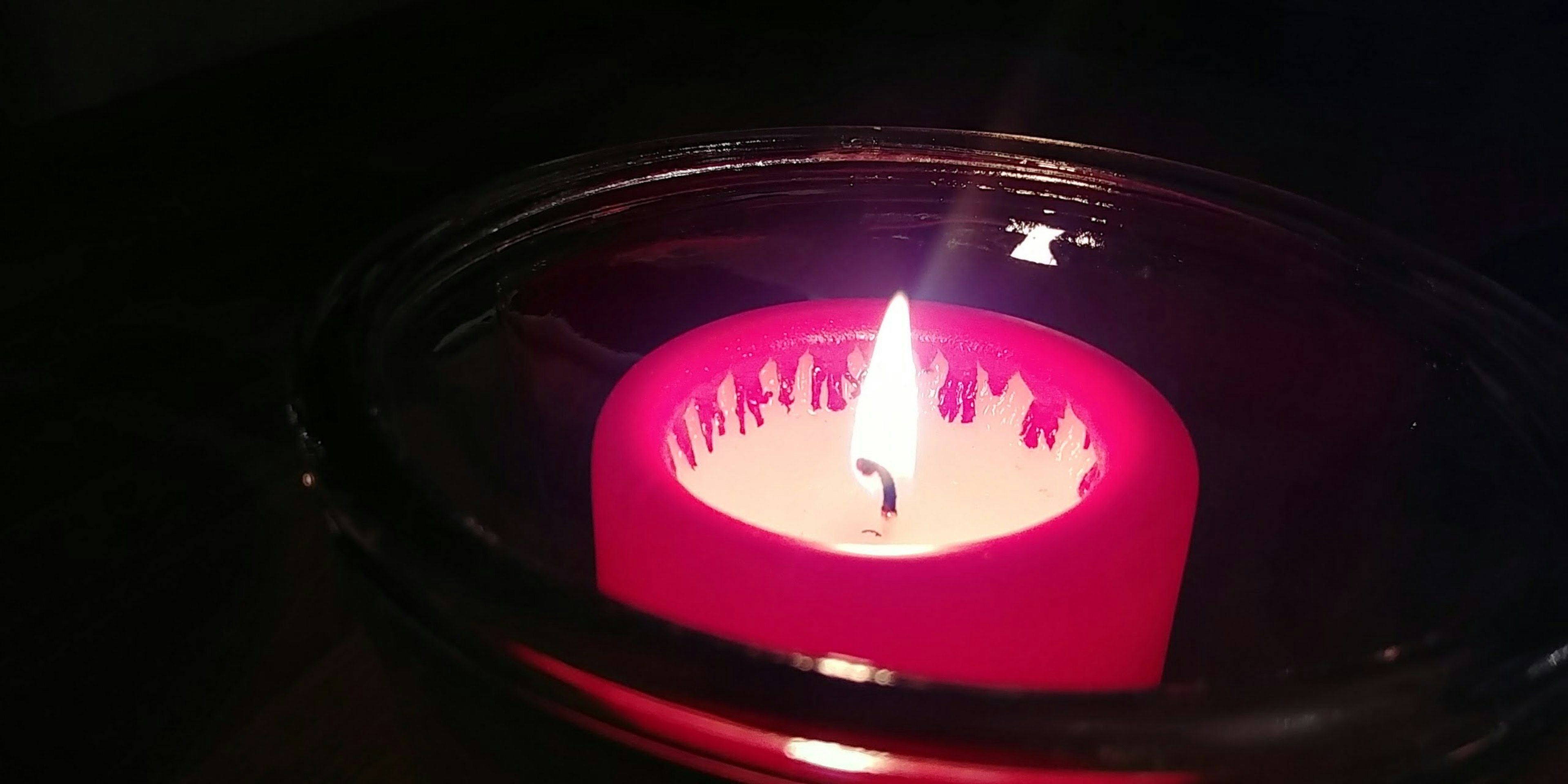 A lit red candle with a visible flame