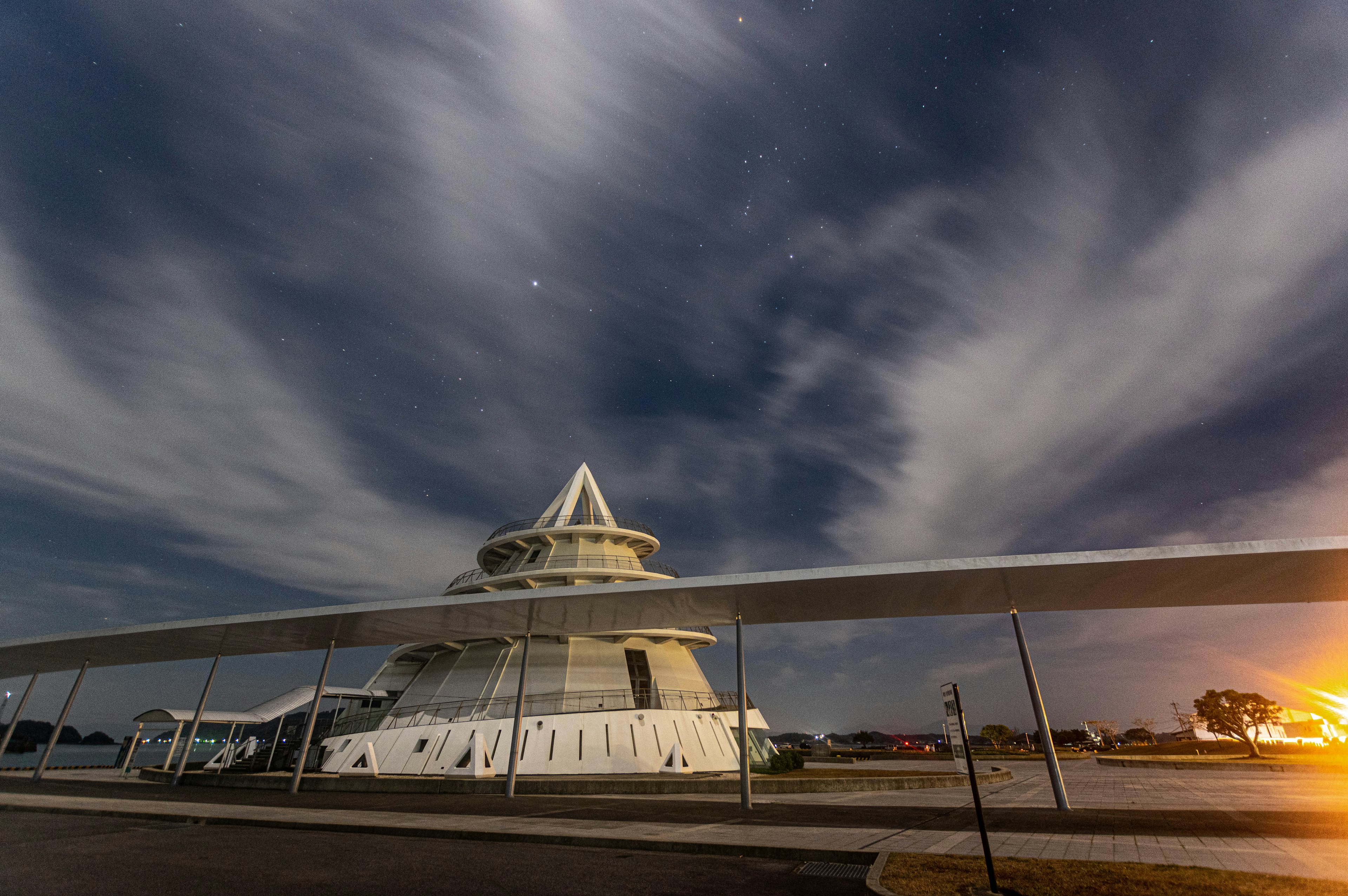 Sebuah bangunan putih di bawah langit malam dengan awan