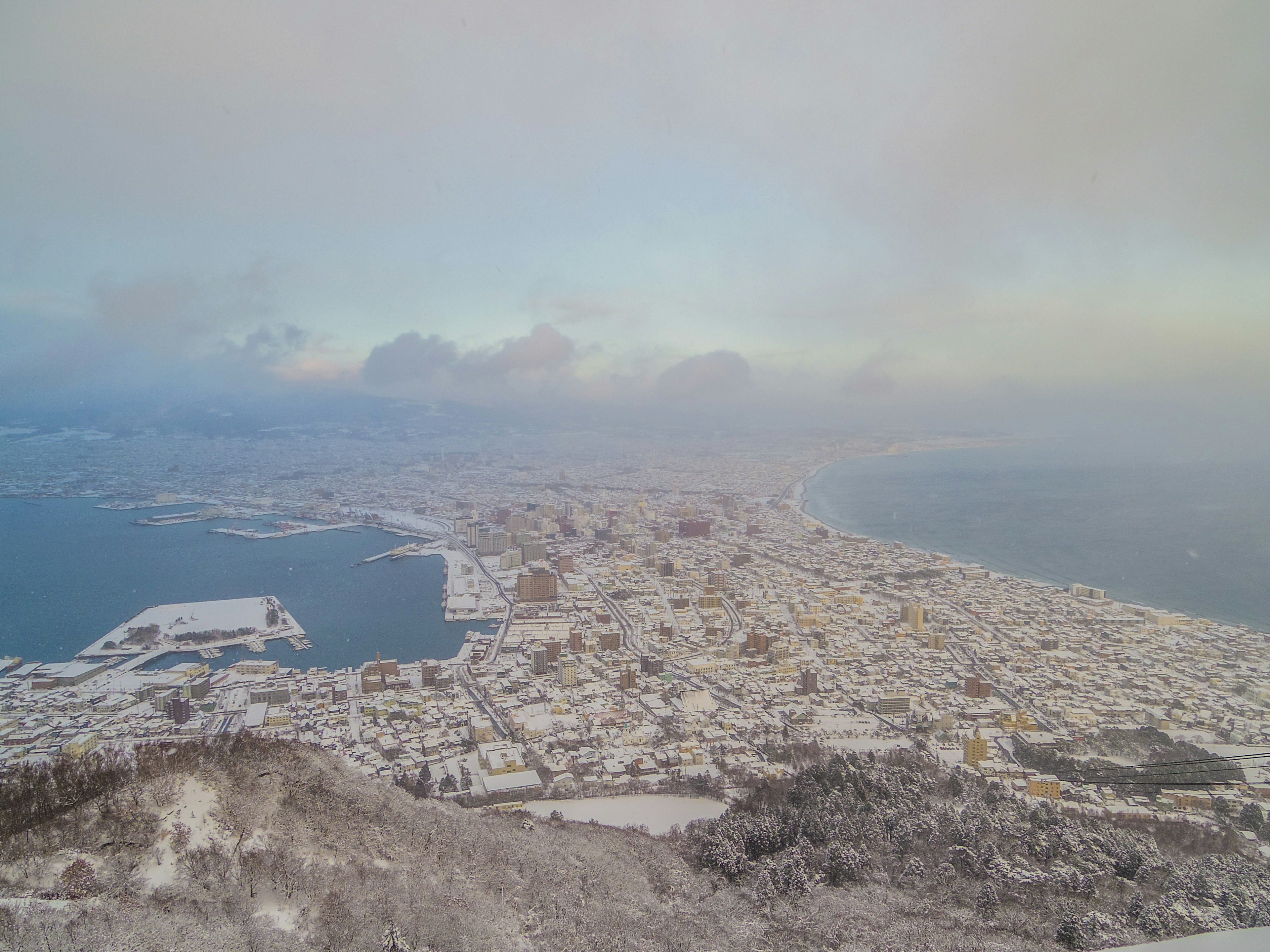 Une vue panoramique d'une ville enneigée et de l'océan